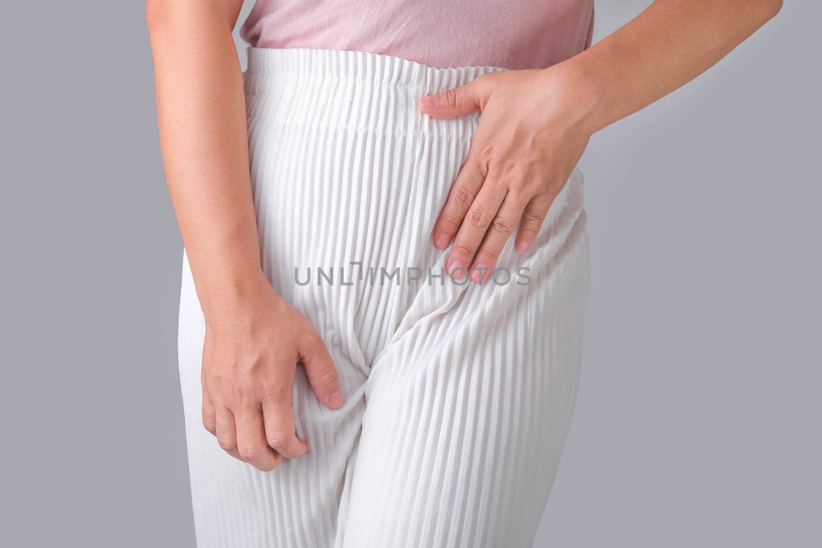 Woman with hands on her crotch isolated on white background. Female hand holding her crotch with pelvic pain or vaginal itching. gynecological problems. Health hygiene concept