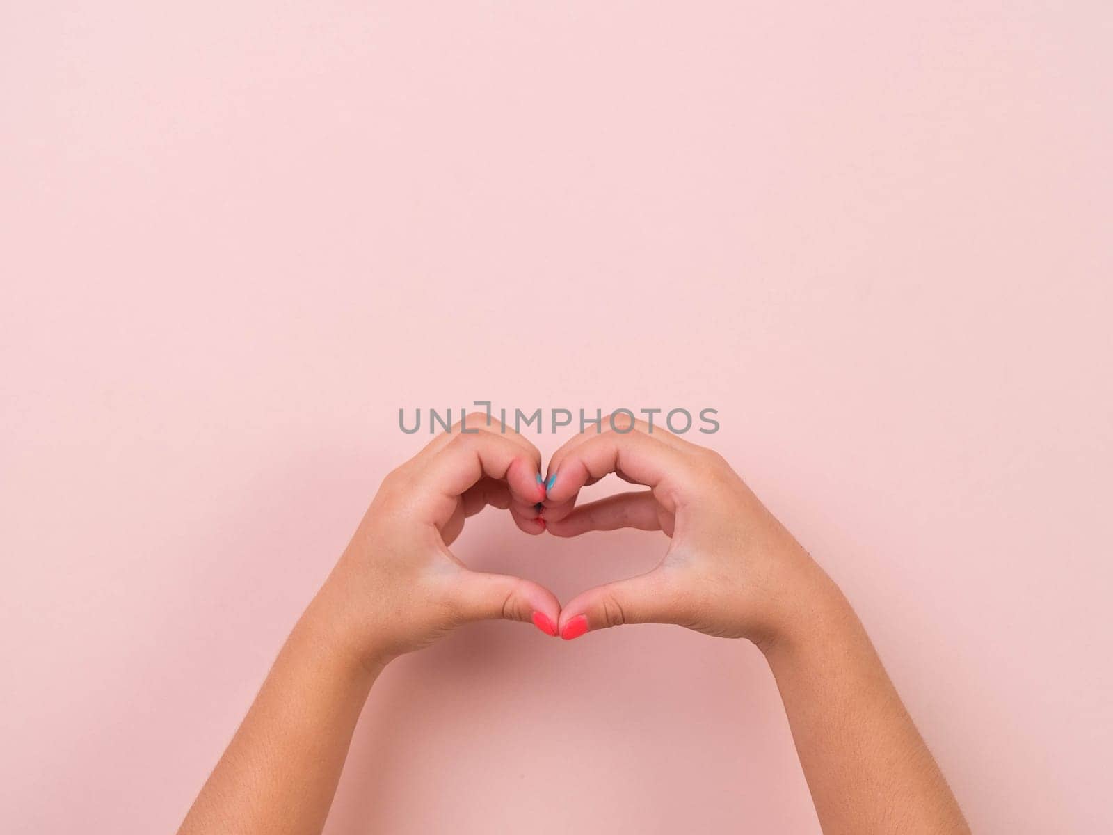 Girl hand showing heart shape, love and sympathy symbol on pink background in studio. Pack of Gestures movements and body language.