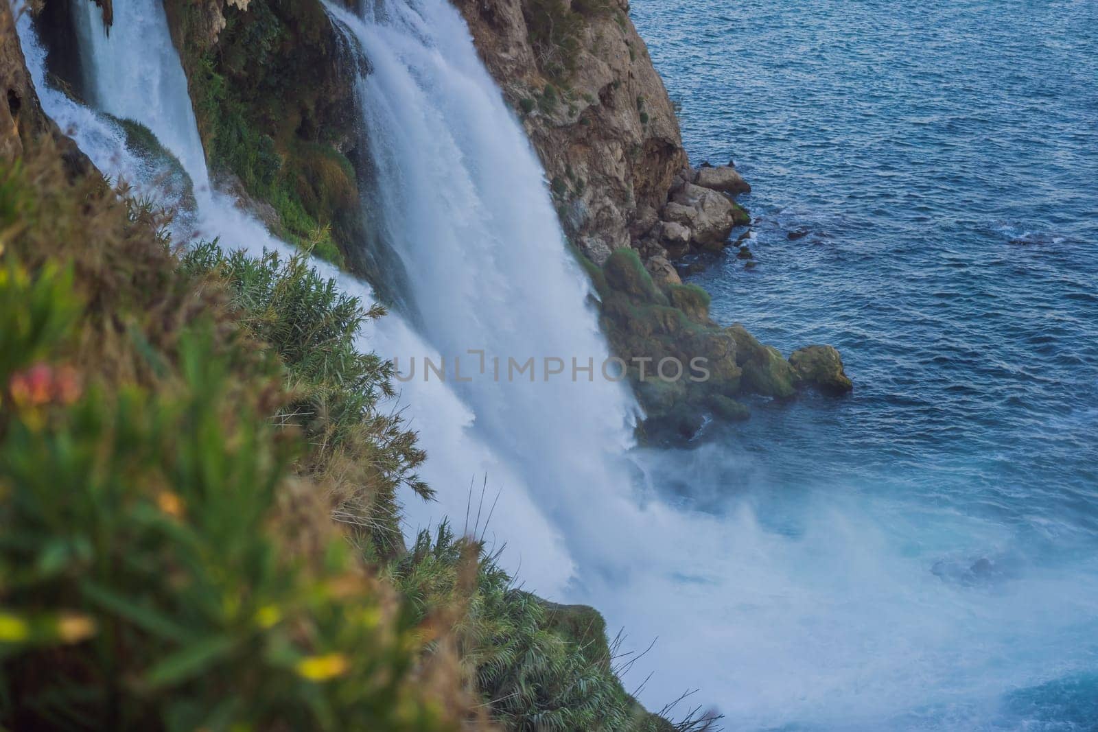 Lower Duden Falls drop off a rocky cliff falling from about 40 m into the Mediterranean Sea in amazing water clouds. Tourism and travel destination photo in Antalya, Turkey. Turkiye