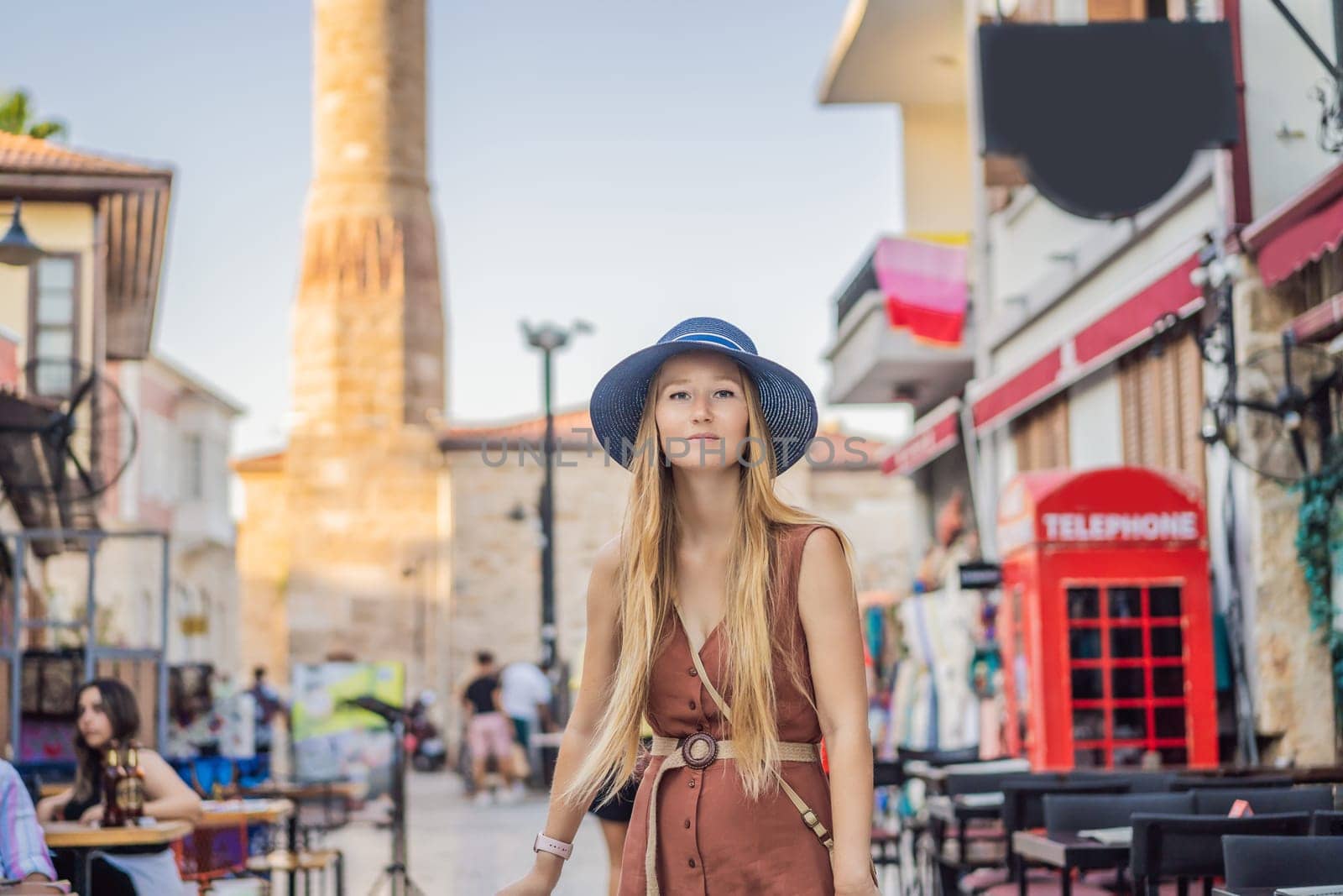 Happy woman tourist on background of old street of Antalya. female tourist traveler discover interesting places and popular attractions and walks in the old city Kalechi of Antalya, Turkey. Turkiye.