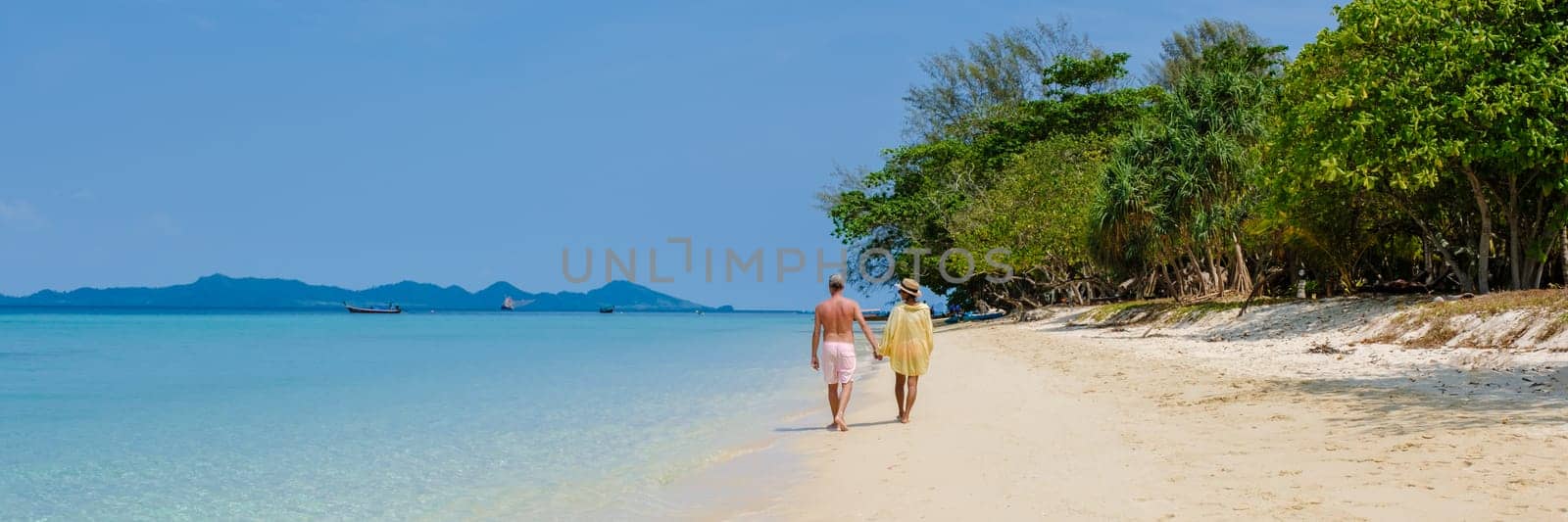 a couple of men and woman on the beach of Koh Kradan Island Thailand by fokkebok