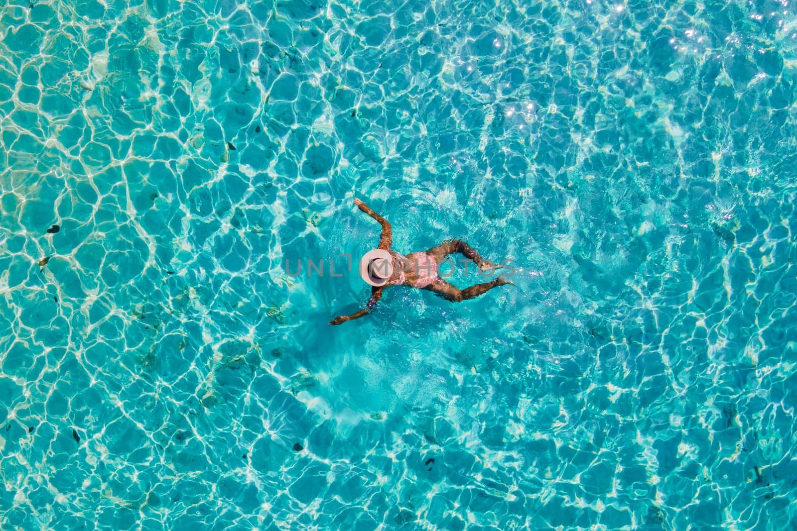 drone view of a woman swimming in the blue turqouse colored ocean of Koh Kradan island in Thailand