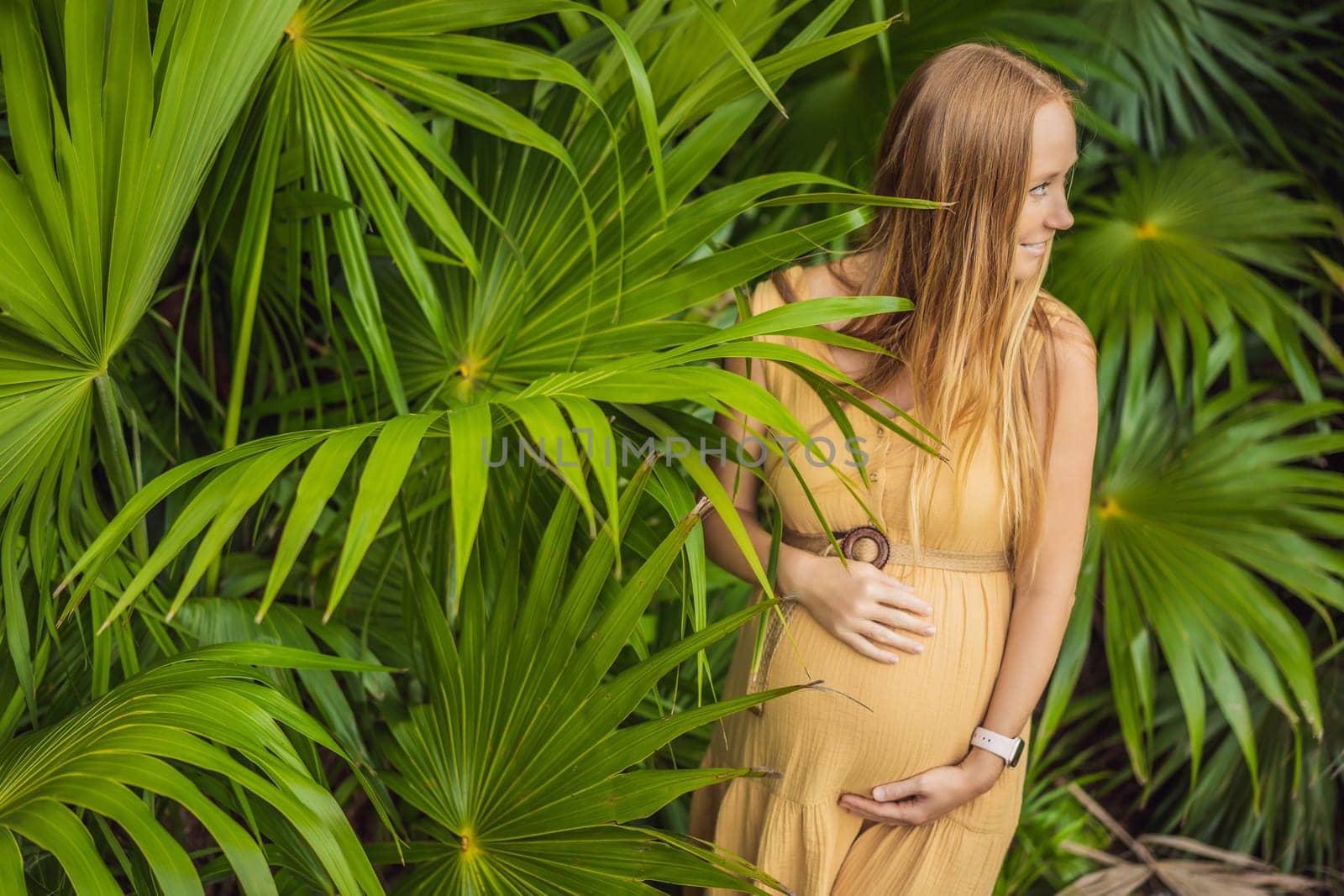 Pregnant woman walks in park at evening. Family enjoying pregnancy. The concept of Mother's Day and Women's Day.