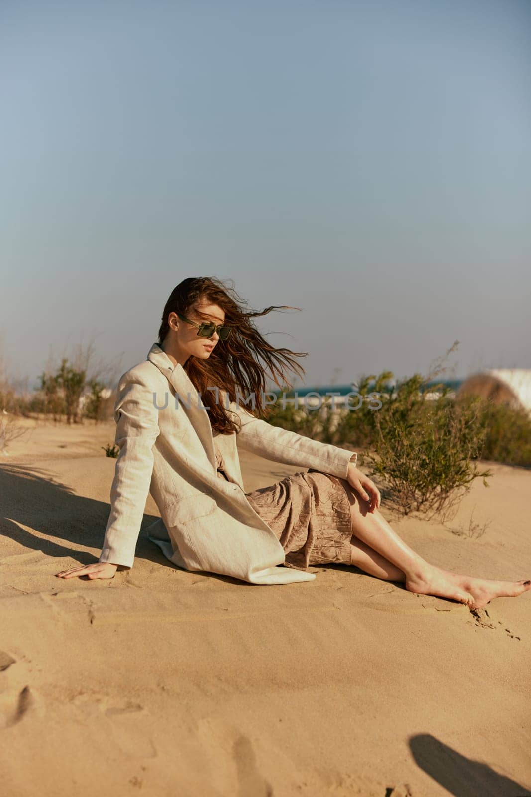 a woman on the beach sits in a stylish jacket during her vacation. High quality photo