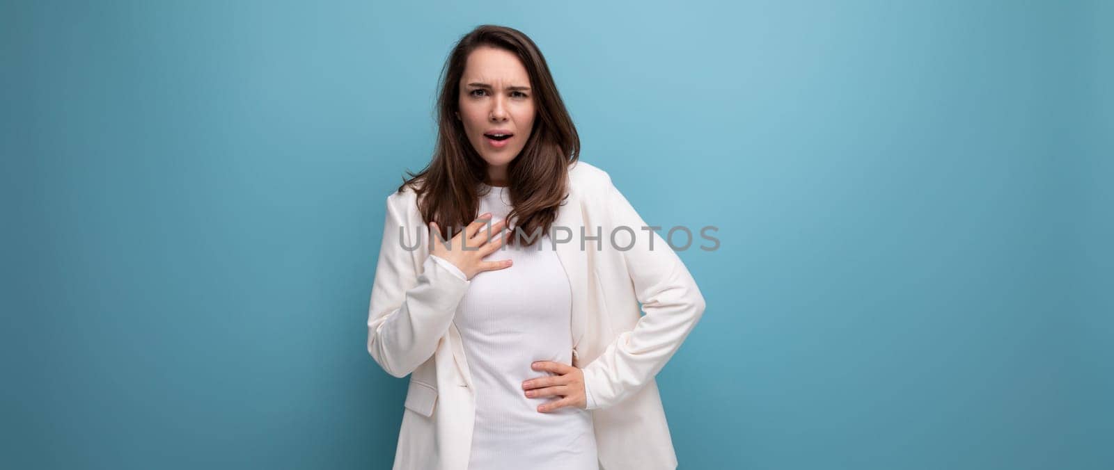 surprised brunette woman in dress with blue copyspace.