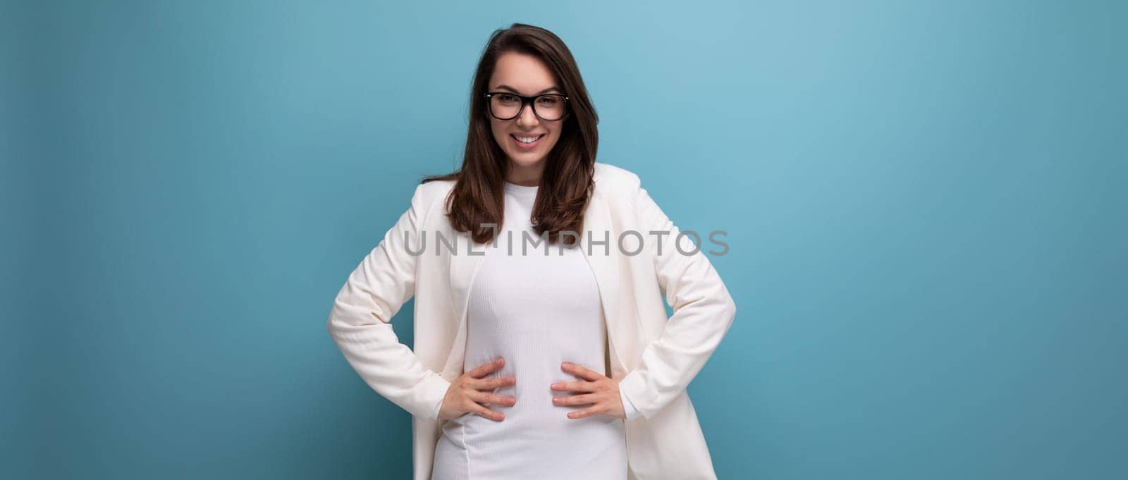business brunette woman in white office dress on blue studio background.