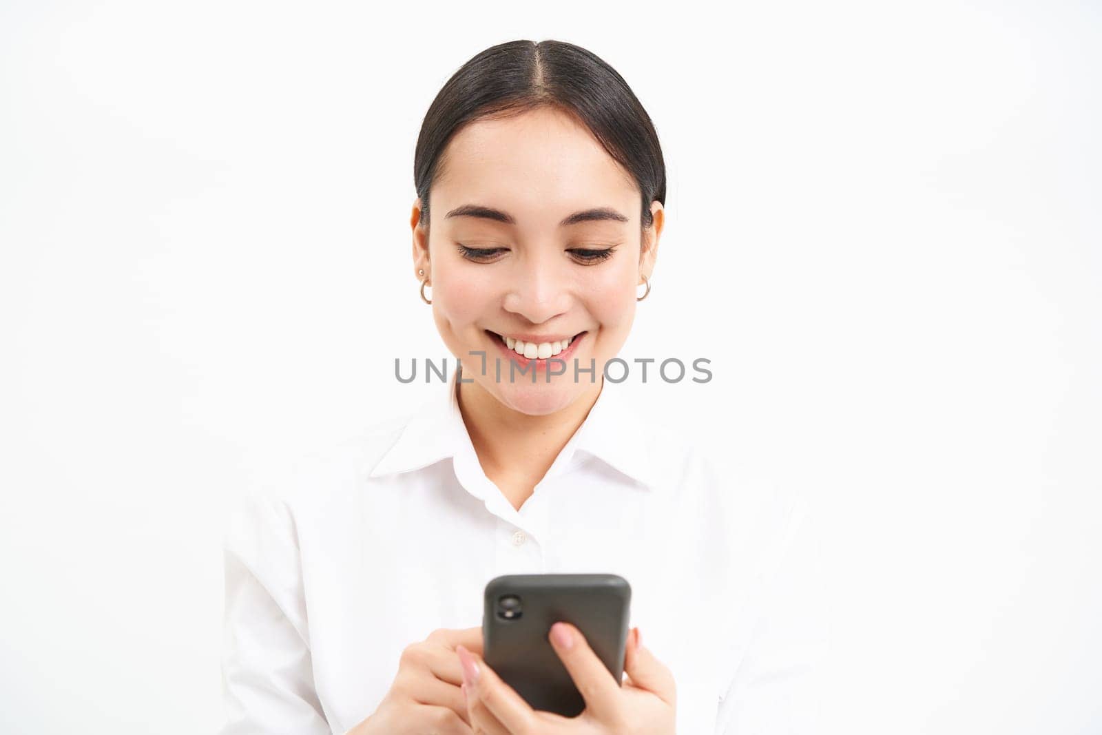 Business and corporate people. Young asian female entrepreneur, looking at smartphone, working on mobile phone, standing over white background.