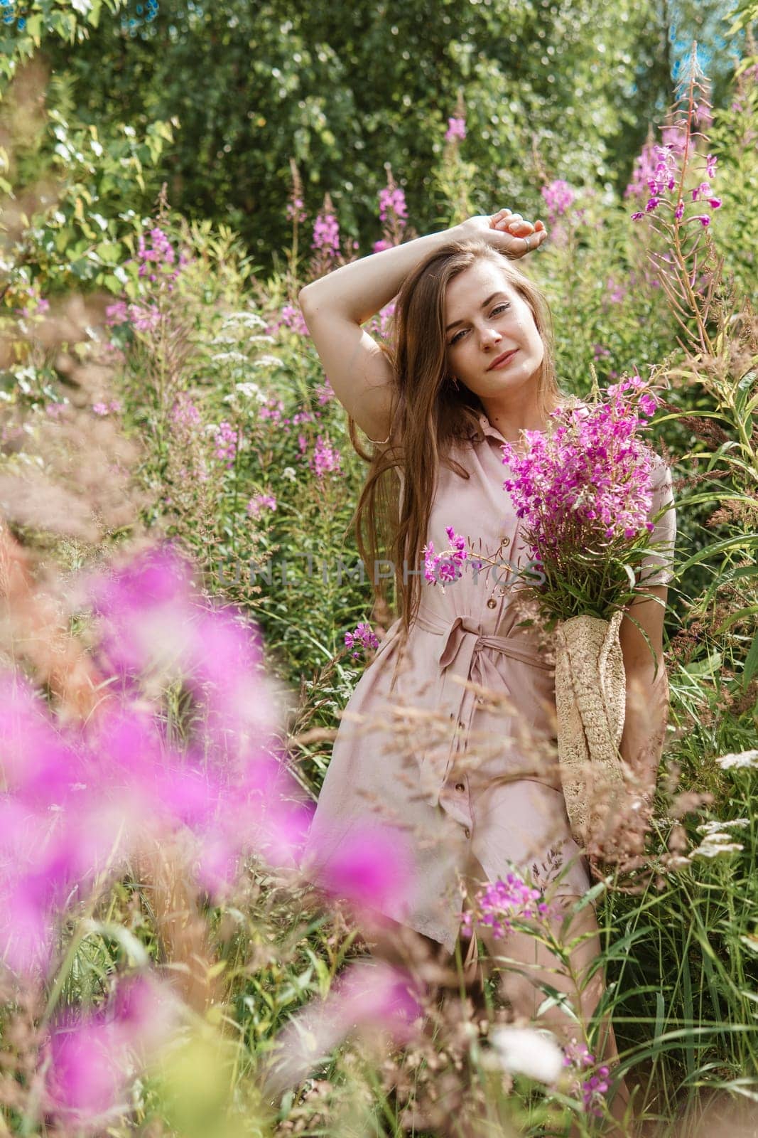 young woman in nature with a bouquet of pink wild flowers. A bouquet of Ivan-tea in the hands of a woman. by Annu1tochka