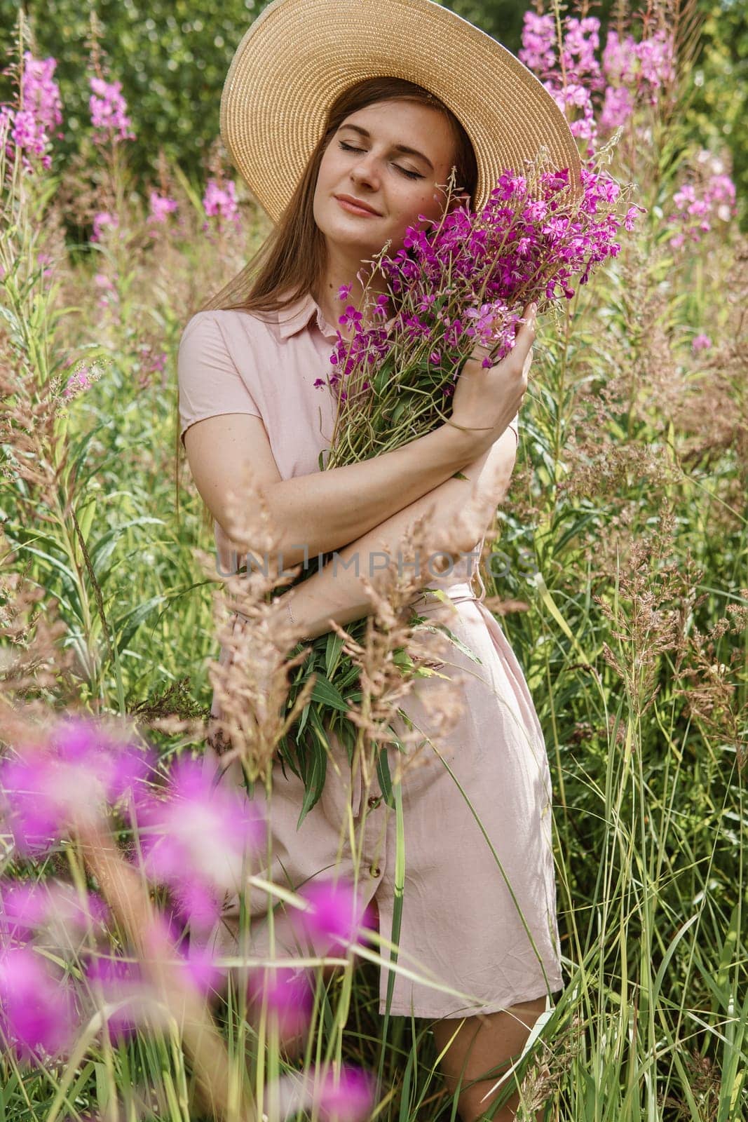 young woman in nature with a bouquet of pink wild flowers. A bouquet of Ivan-tea in the hands of a woman. by Annu1tochka