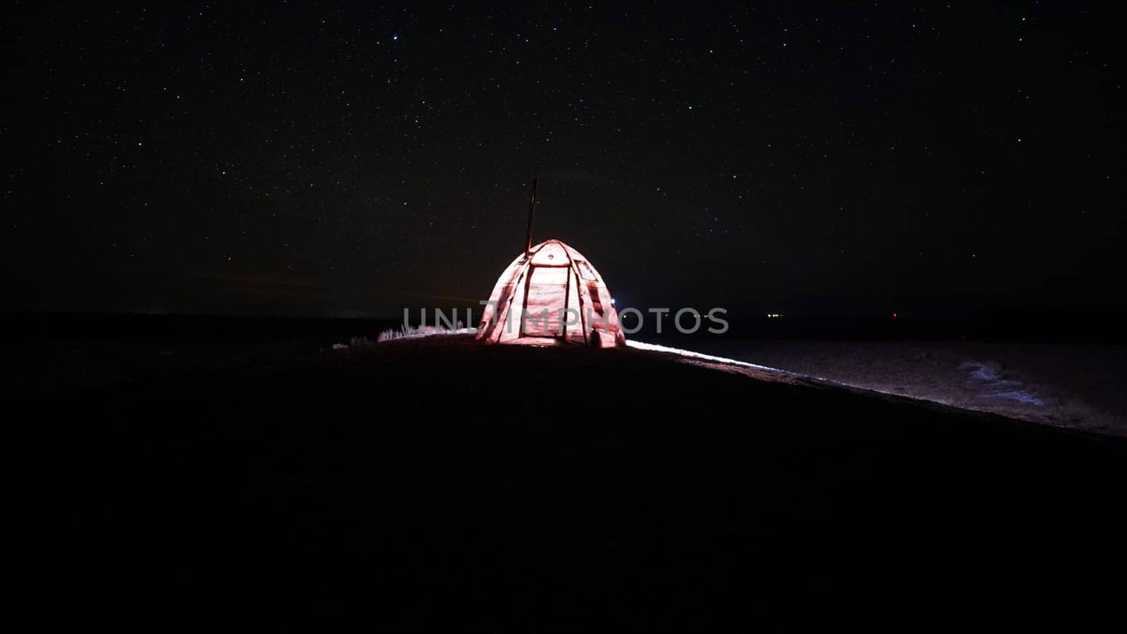 A tent with a stove stands under the starry sky. by Passcal