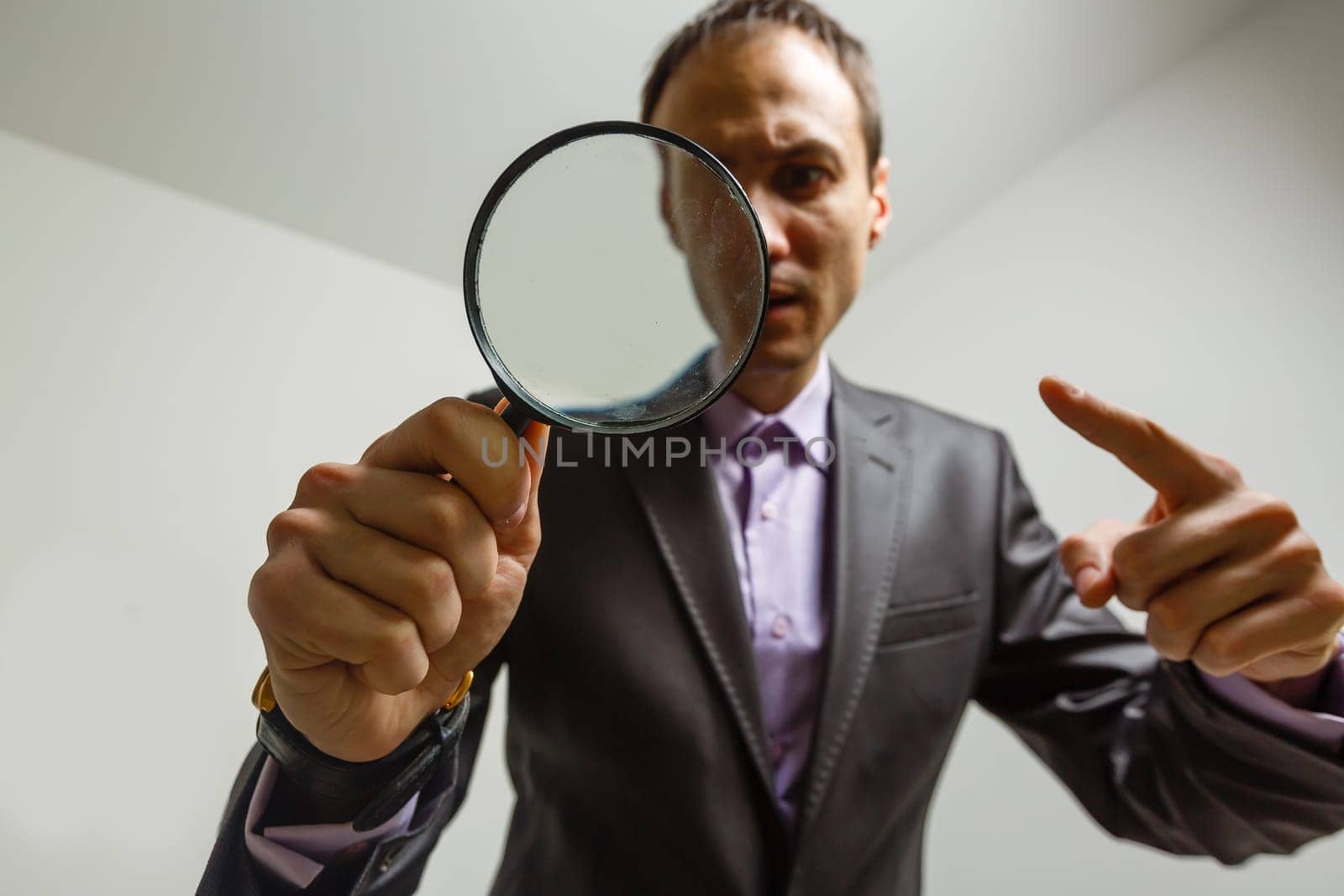 Man hand holding magnifying glass. Data search and analysis, conducting research, nuances, important details study, preparation for exams concept by Andelov13