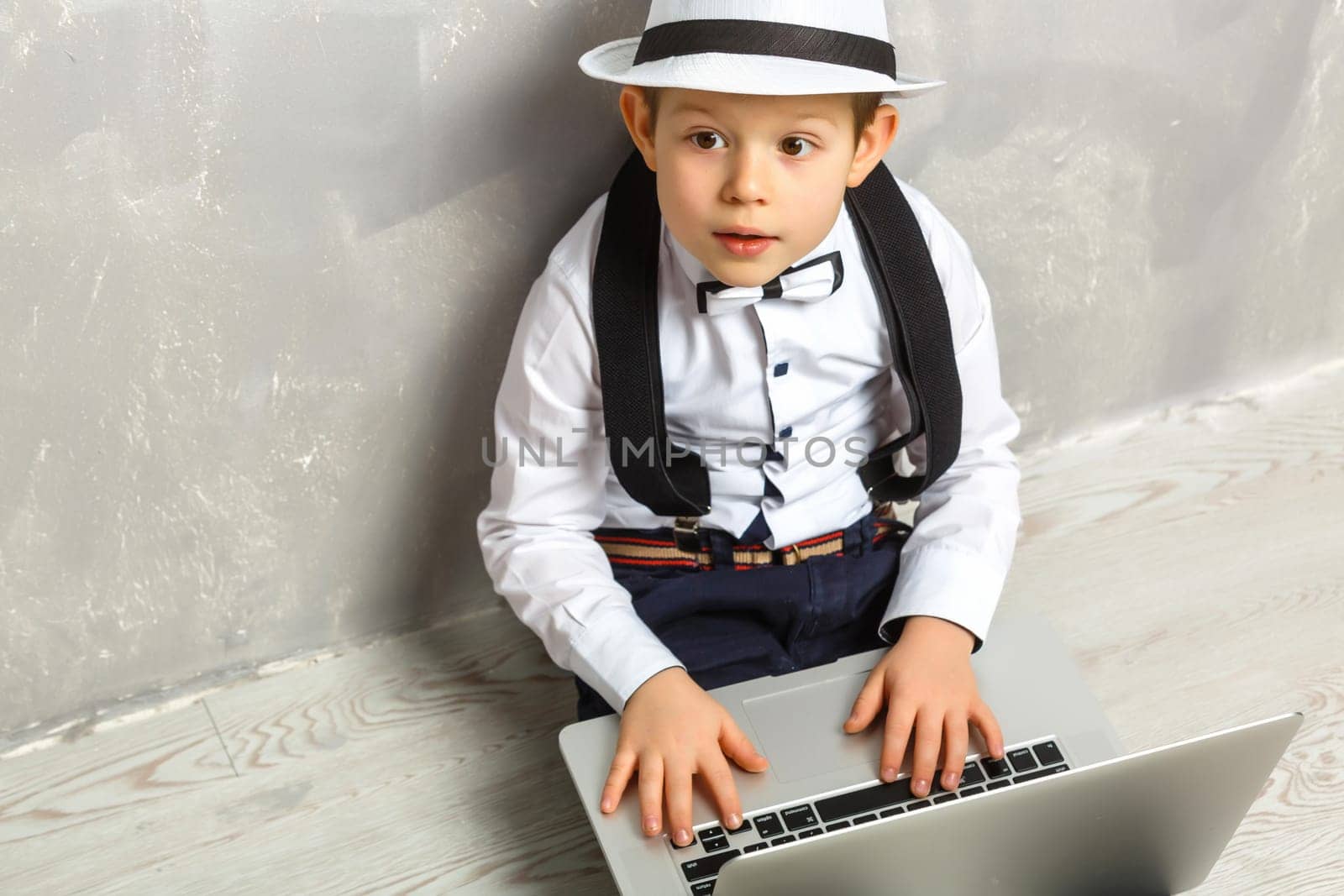 Portrait of Genius. Young boy working on the computer sitting On the floor. Studying. Online learning remotely. Distant school. Distance education. Online courses and knowledge. by Andelov13