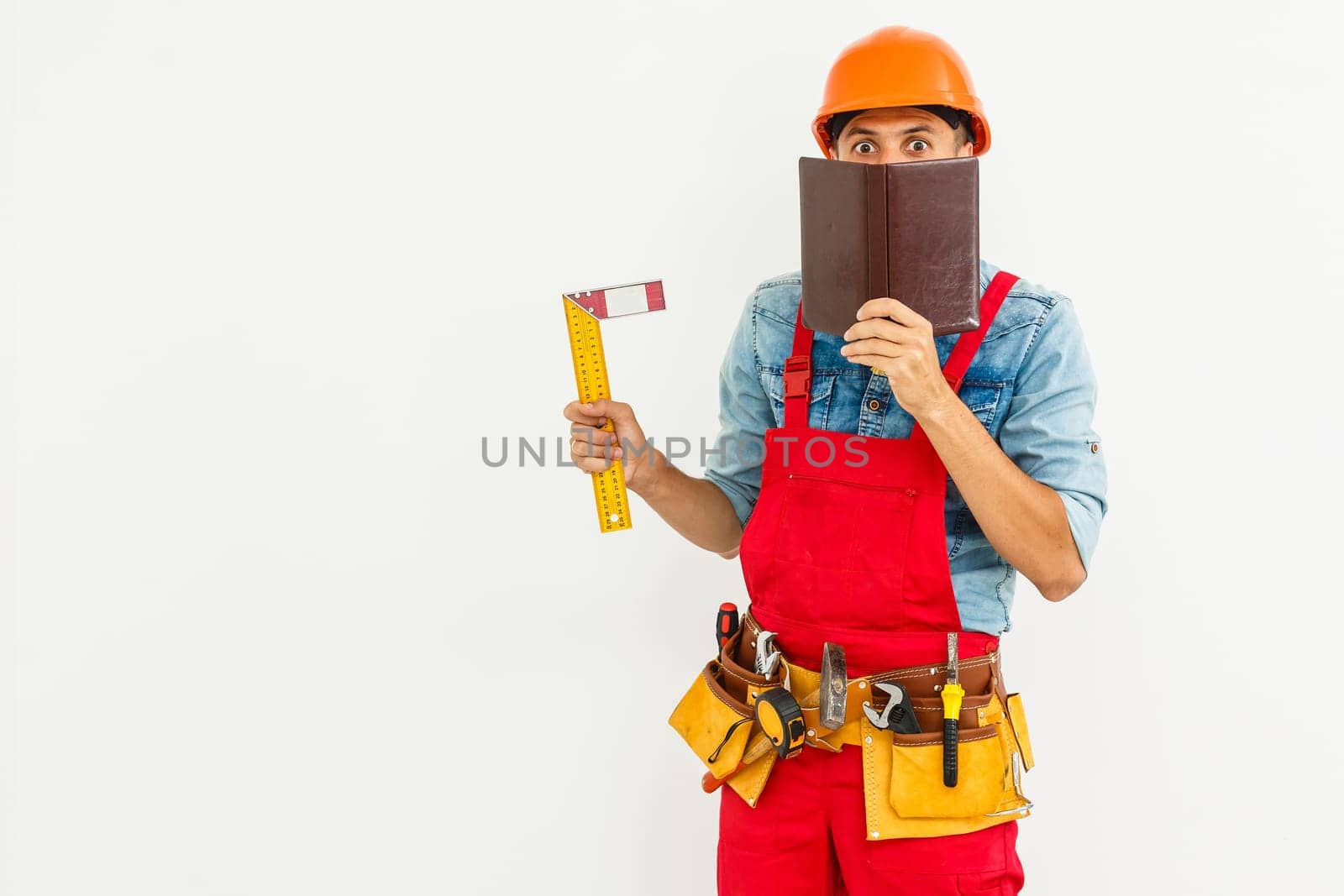 Portrait of cheerful young worker wearing hardhat over white background.