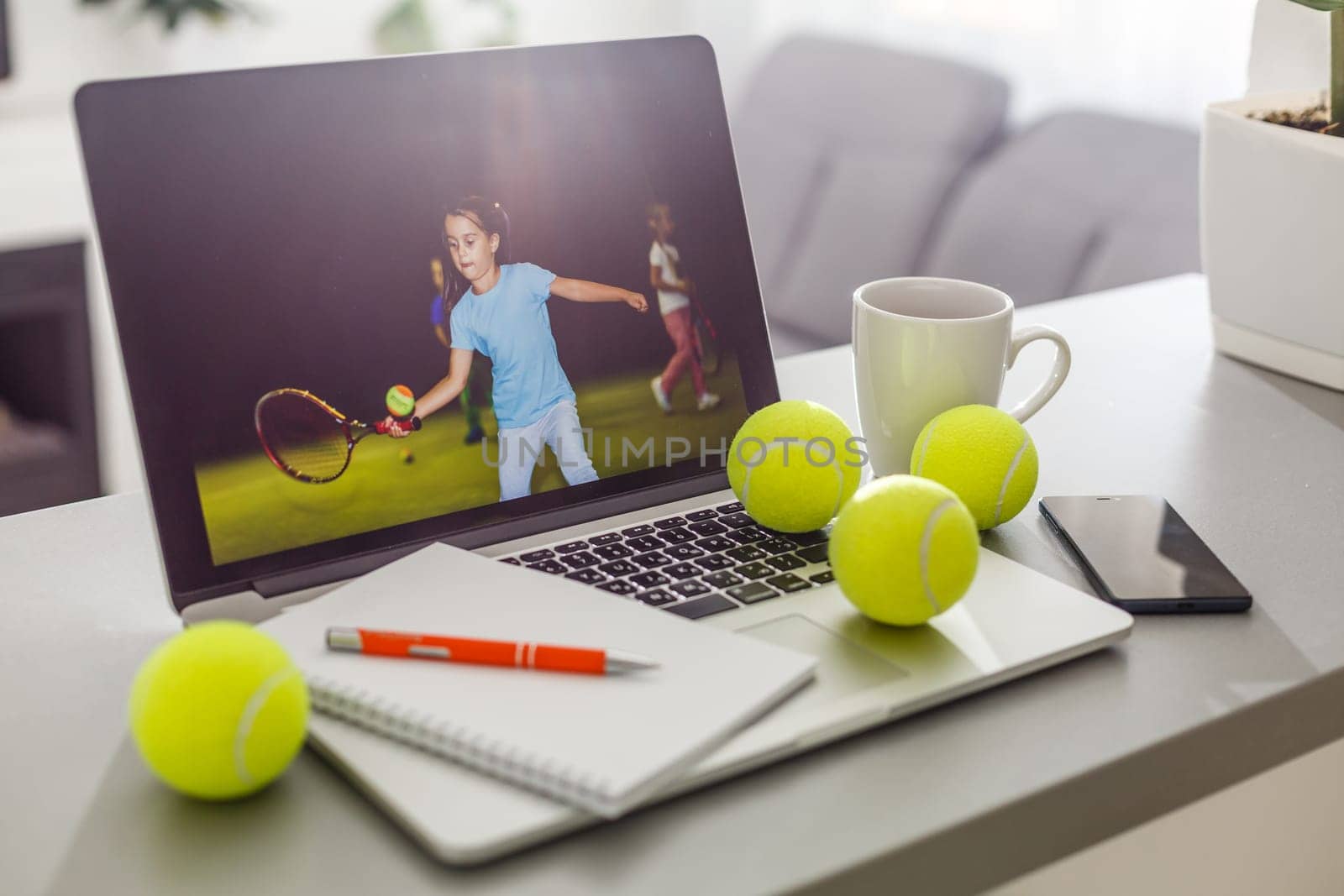 Top view of laptop, Sports Equipment, Tennis ball, the Sports administration gray table. Business concept