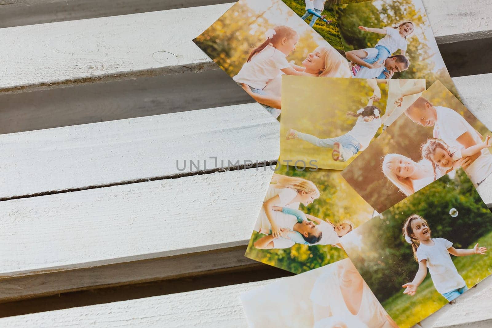 printed photos of family summer vacation lying on desk