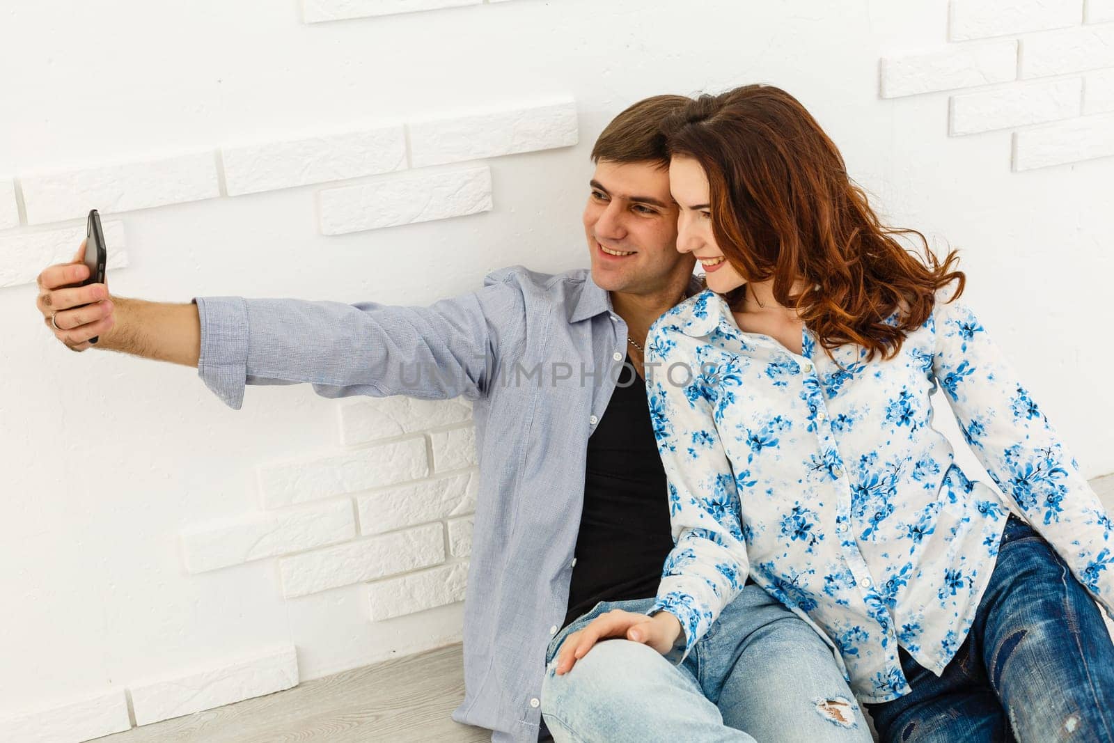 Close up photo of lovely a couple of selfies. They are happy, having fun and taking a selfie, on grey abckground.