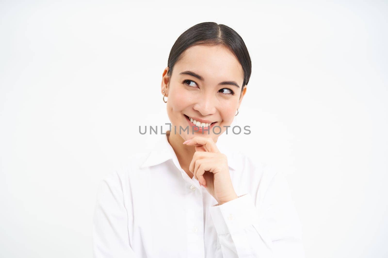 Portrait of businesswoman, asian lady boss thinks, looks thoughtful, pondering something with serious face, standing over white background.