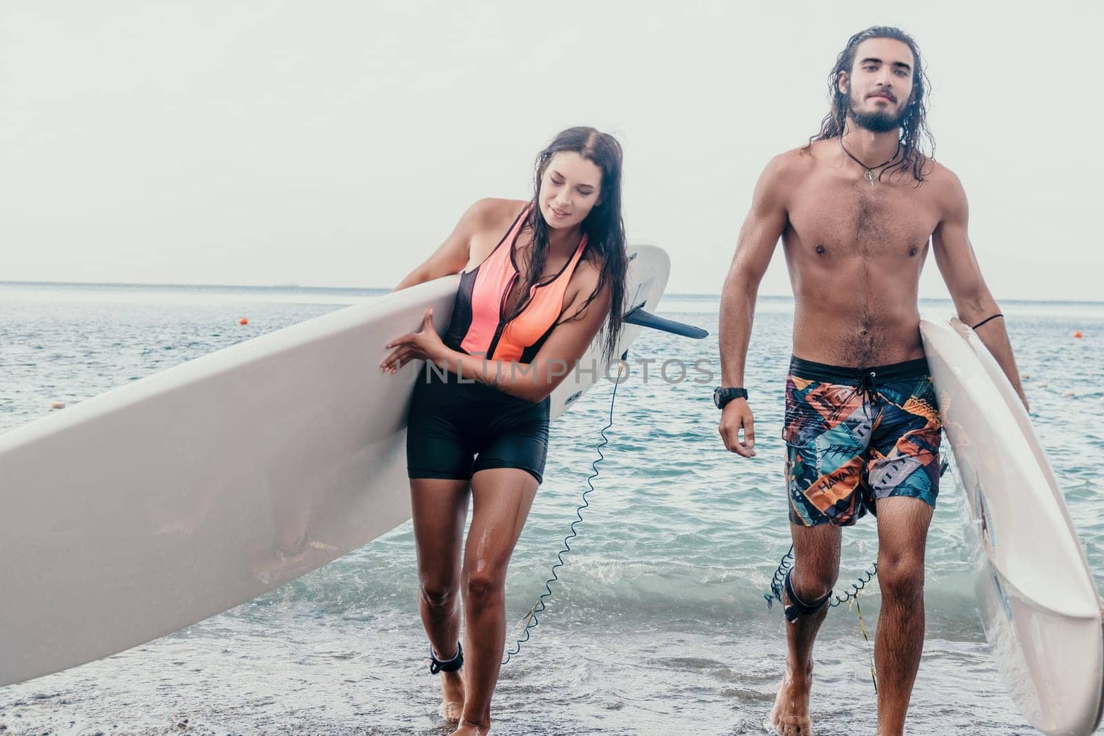 Sea woman and man on sup. Silhouette of happy young woman and man, surfing on SUP board, confident paddling through water surface. Idyllic sunset. Active lifestyle at sea or river