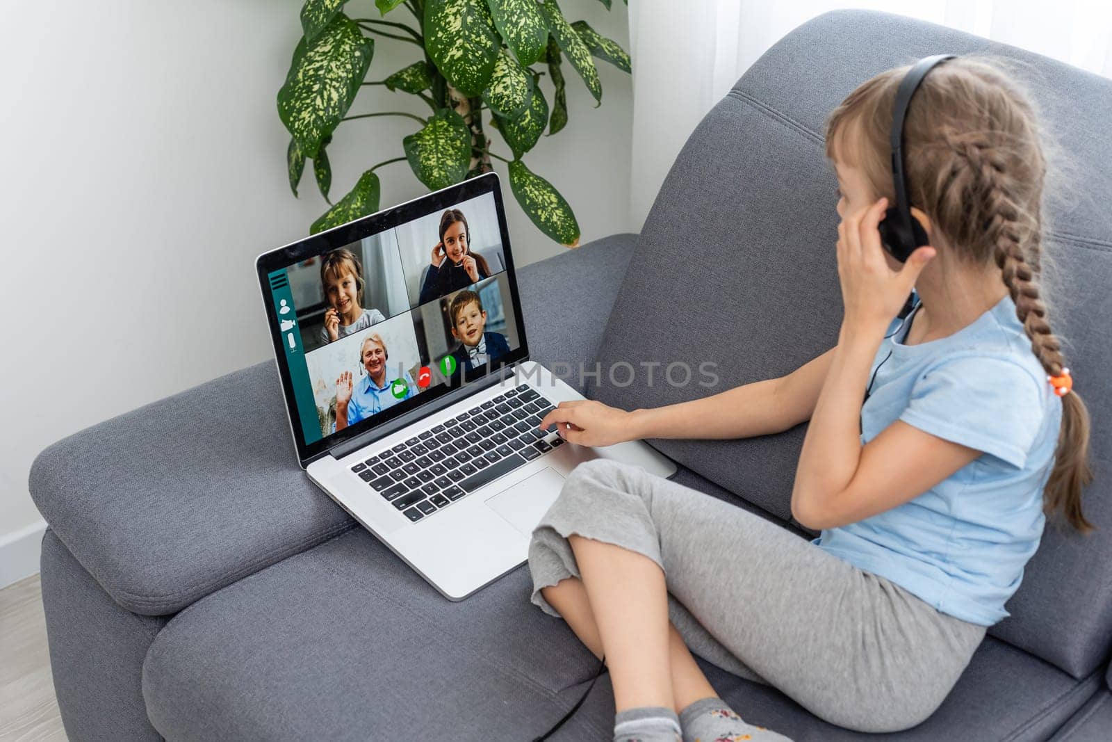 Back view of young girl sit at home talk have online video call lesson with teacher or tutor, teenage schoolgirl engaged in webcam conversation, study distant use web conference app on laptop.