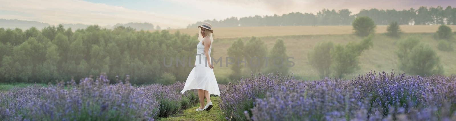 Beautiful young woman in wicker hat and white dress in a lavender field with by Andelov13