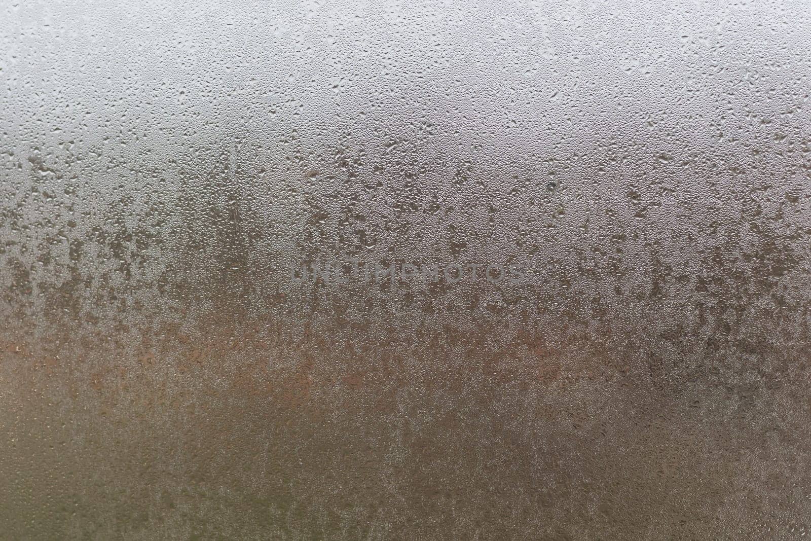 Water droplets condensation background of dew on glass, humidity and foggy blank. Outside, bad weather, rain.