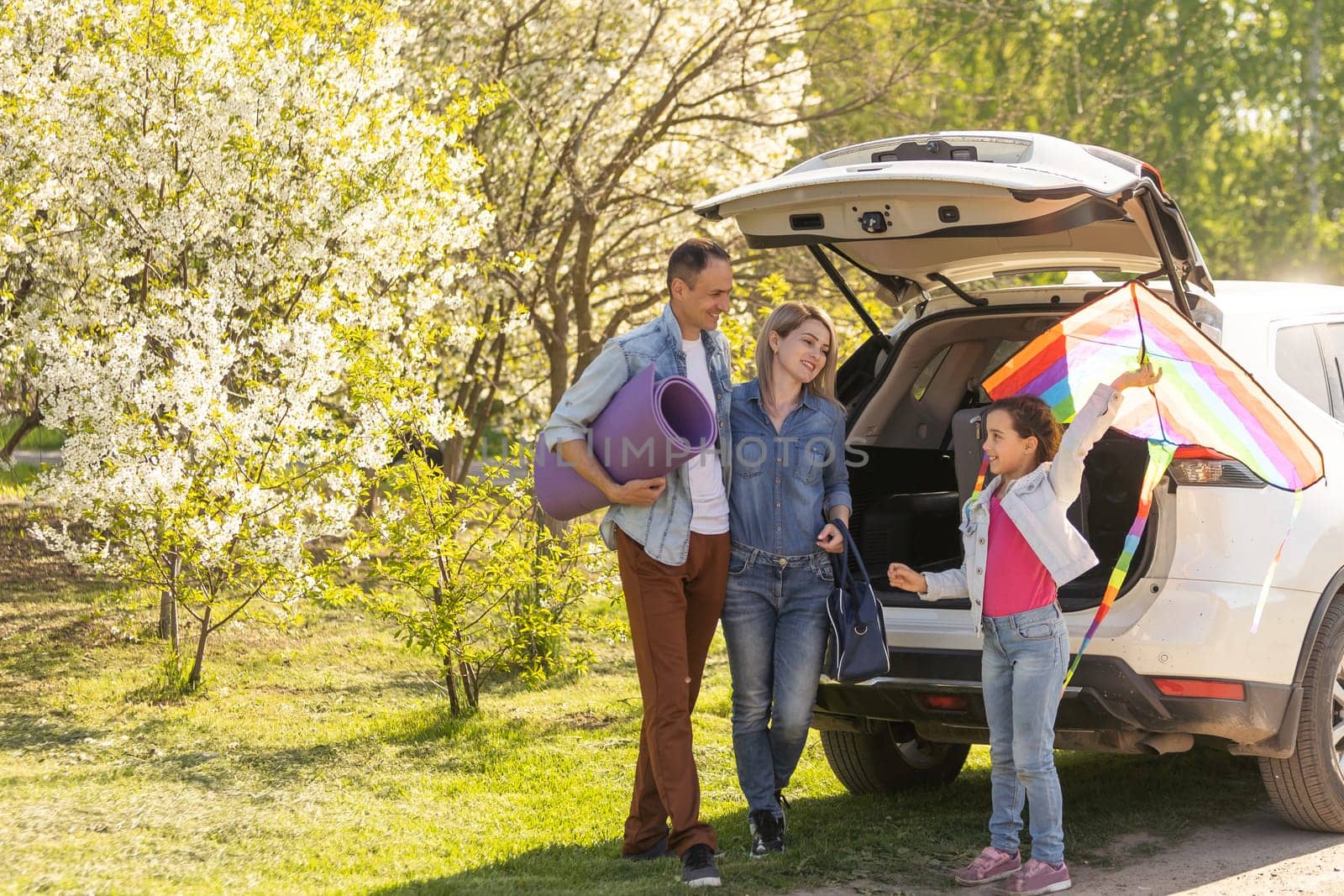 parents and child stopped for break by car. happy family travels by car. Car travel concept. healthy family.