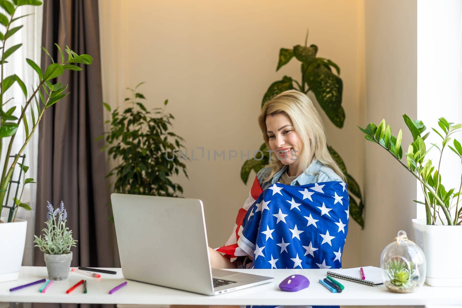 woman holding usa flag and video by laptop by Andelov13