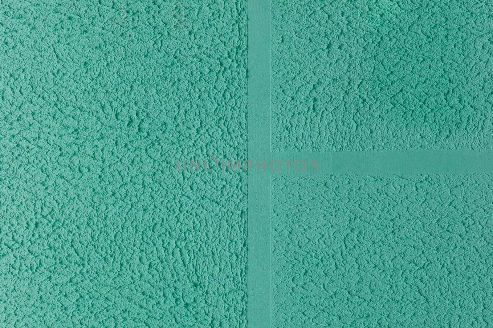 Green aquamarine turquoise azure plaster wall abstract pattern texture coarse surface background rough stucco.