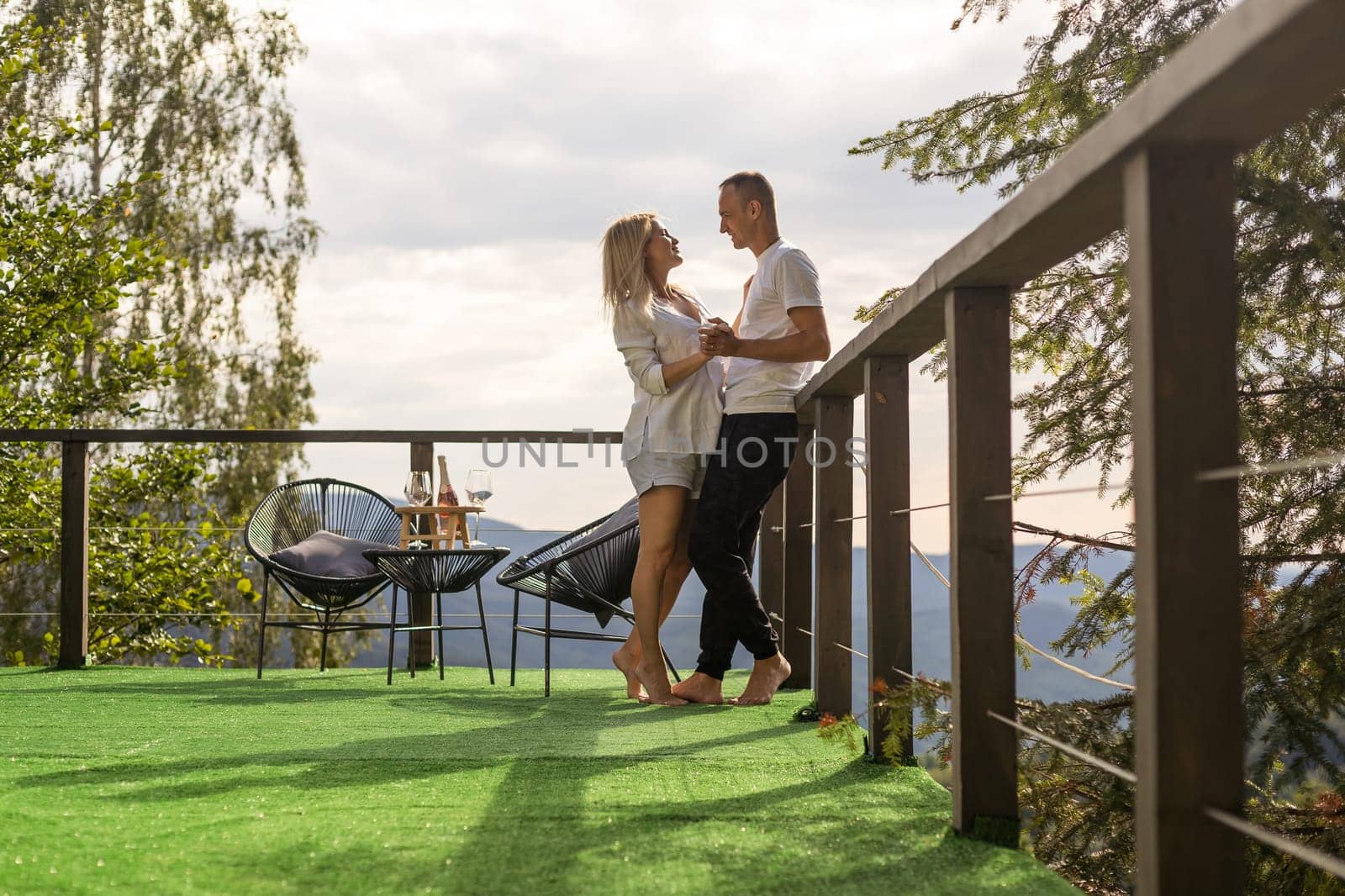 Couple on the balcony against the backdrop of mountains. life terrace pretty happiness summer home