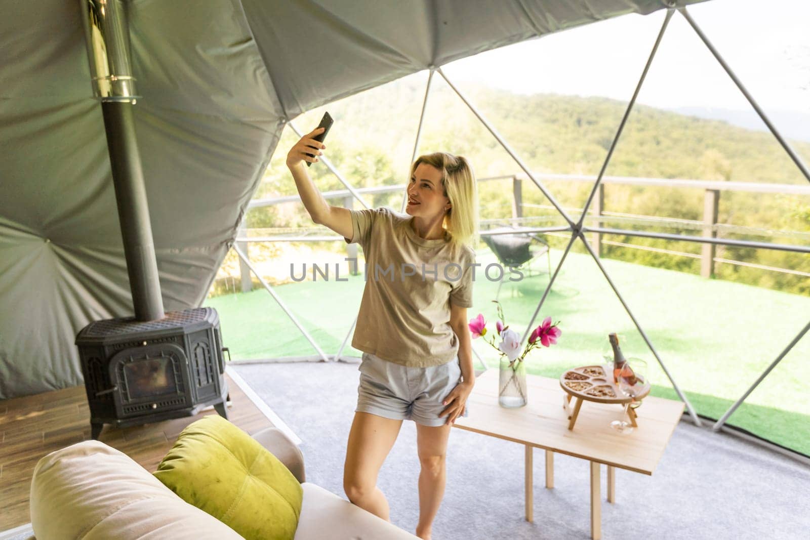 woman with smartphone in geo dome tent by Andelov13