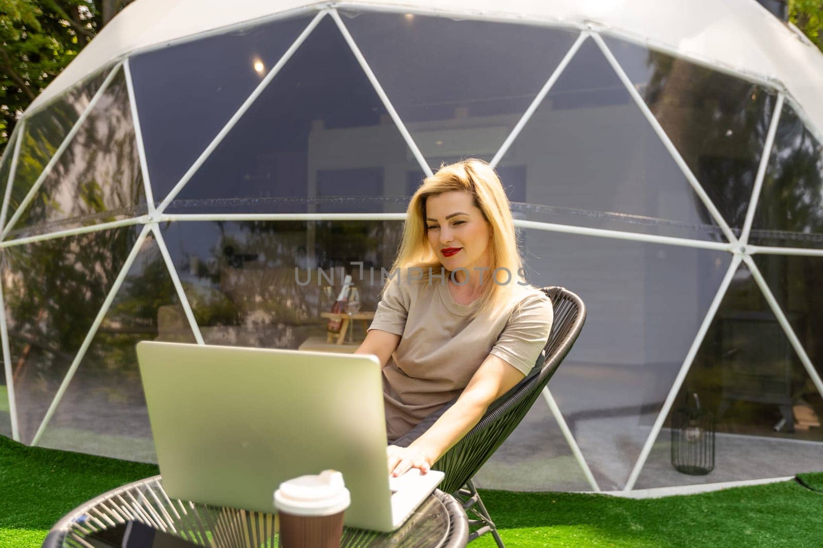 woman working on laptop Outdoor Bubble Tent House Dome - Nature travel Concept