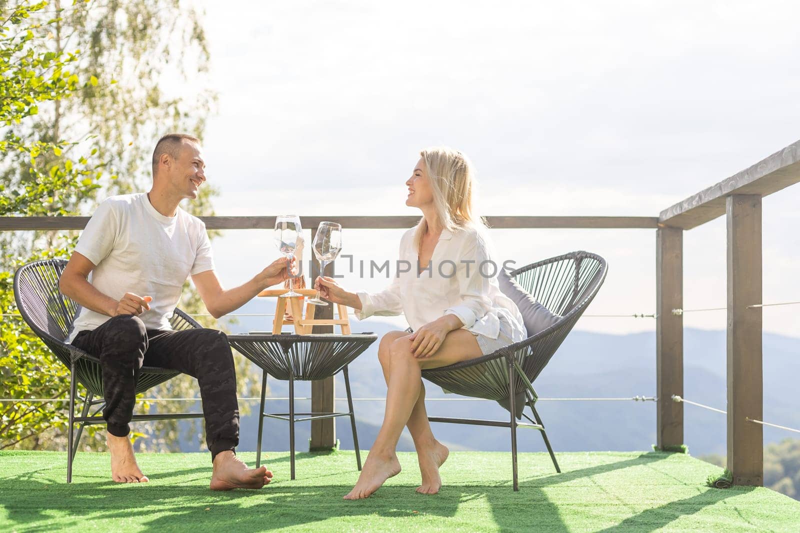 Happy couple sitting in a cozy home with a mountain view