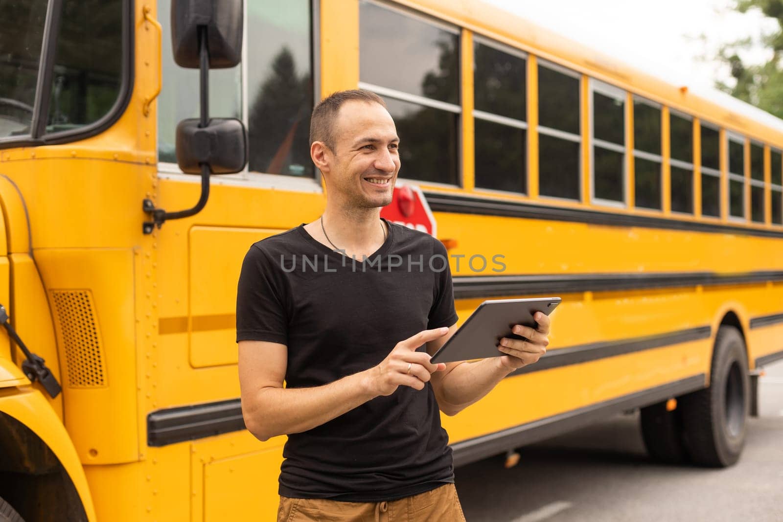 Portrait of teacher standing near the school bus