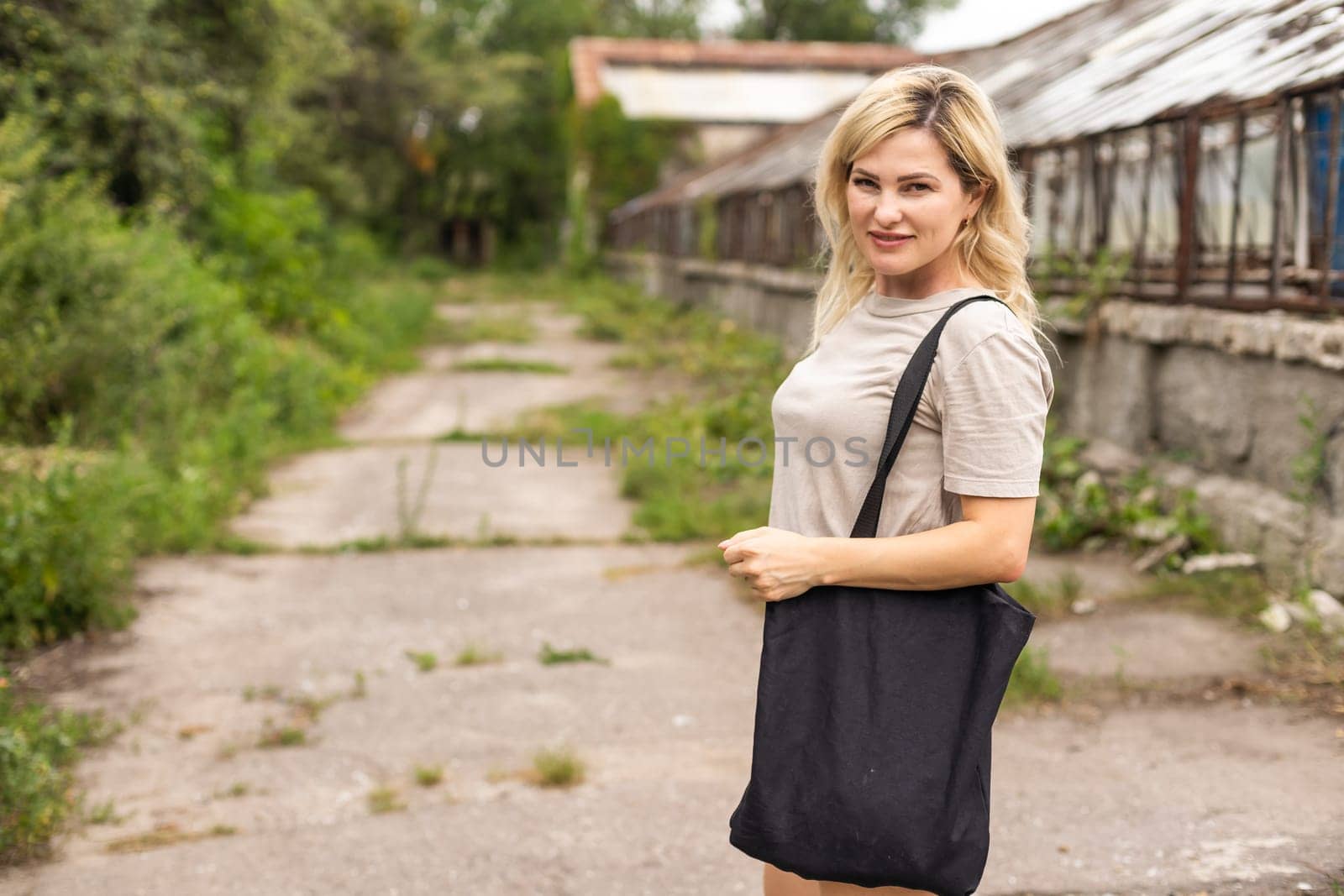 consumerism, eating and eco friendly concept - woman with reusable canvas bag for food shopping.