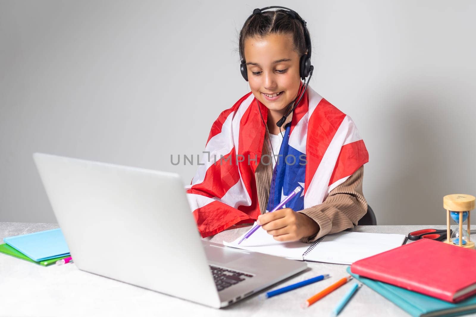 little girl studying with laptop and usa flag.