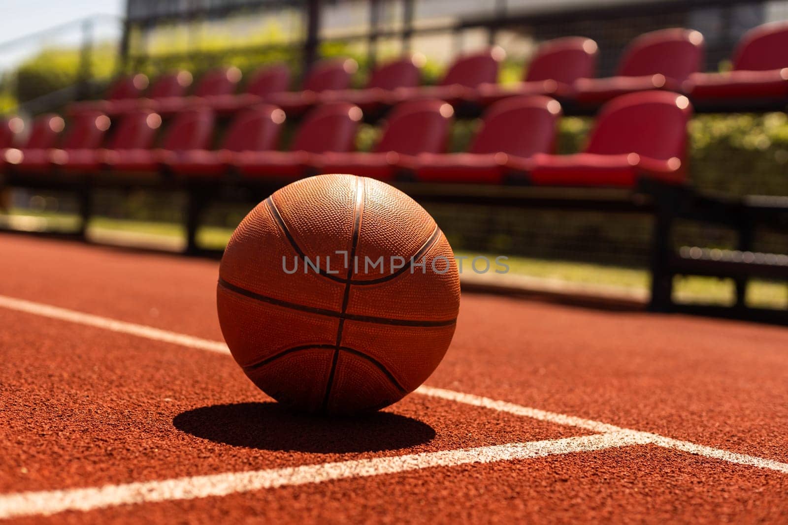 Basketball on Court Floor close up with blurred arena in background by Andelov13