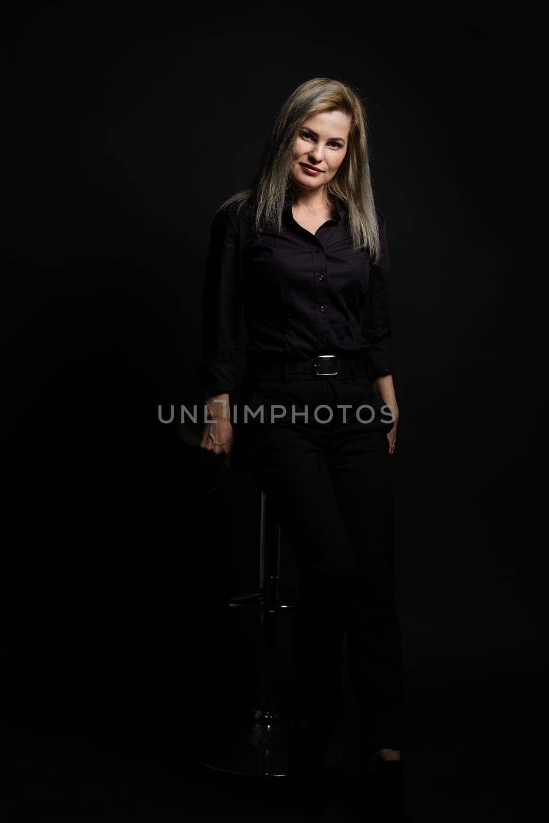 woman in black on a black background.