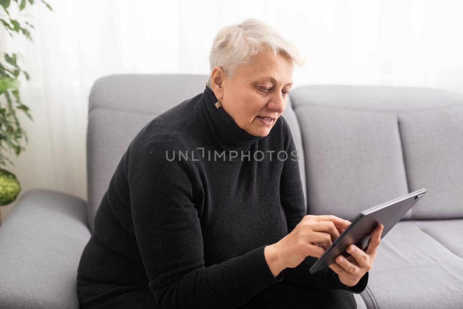 Old woman using blank screen tablet