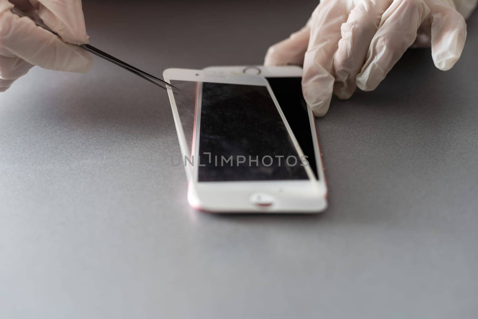 Technician or engineer preparing to repair and replace new screen broken and cracked screen smartphone preparing on desk with copy space by Andelov13
