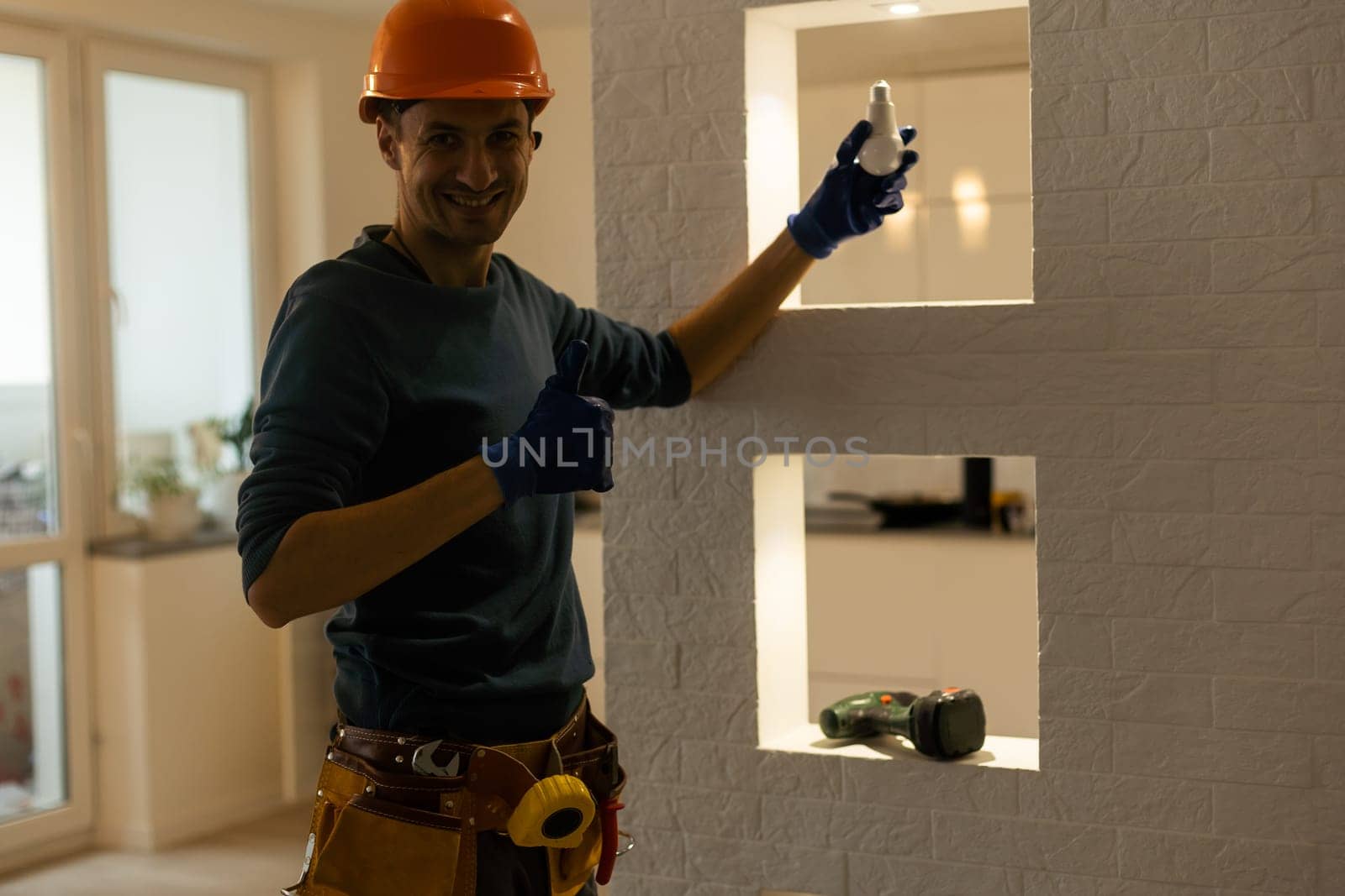 Portrait of an electrician holding an energy-saving lightbulb.