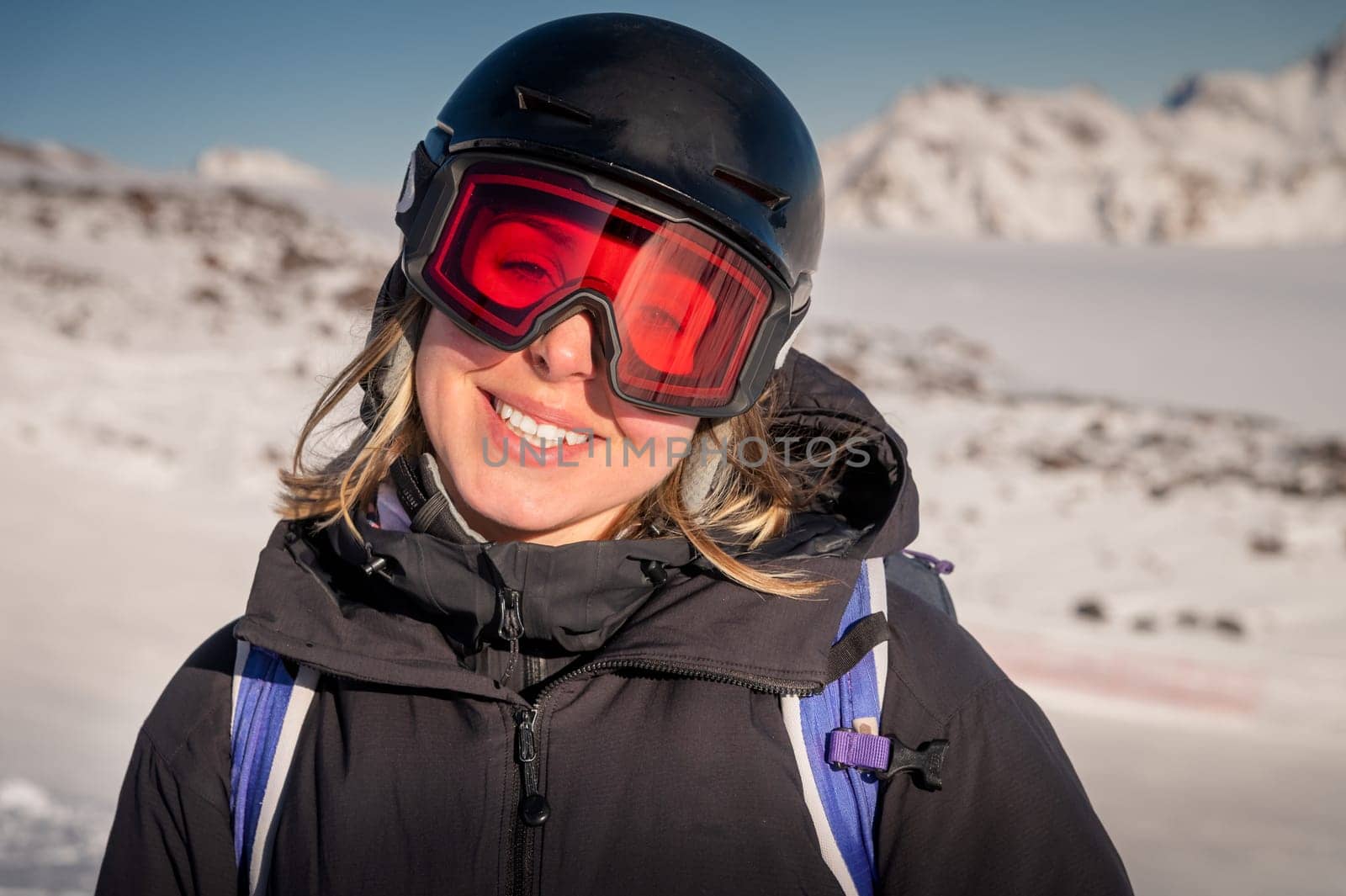 Skier smiling happy cheerful satisfied woman in warm windbreaker jacket ski goggles mask glasses spend extreme weekend in mountains on resort.