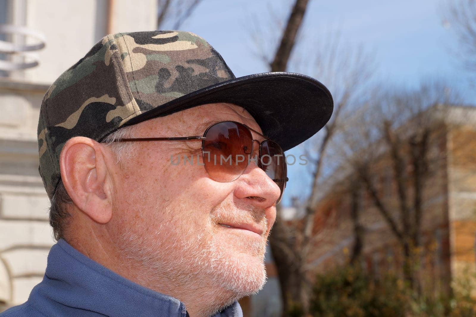 smiling man in cap and sunglasses close up.