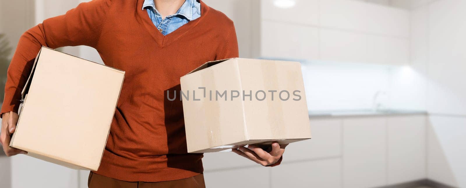 young man carrying three carton boxes.