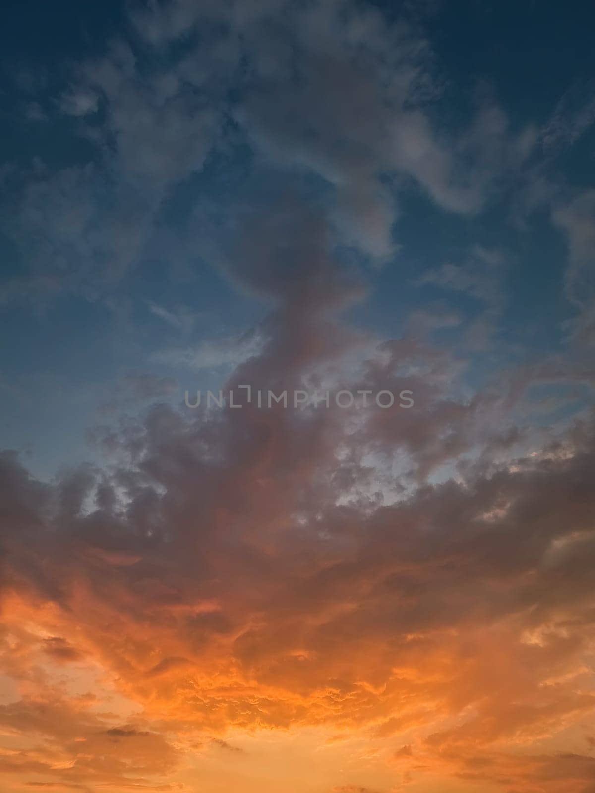 Beautiful sunset sky with colorful orange clouds over the horizon, vertical celestial background by psychoshadow