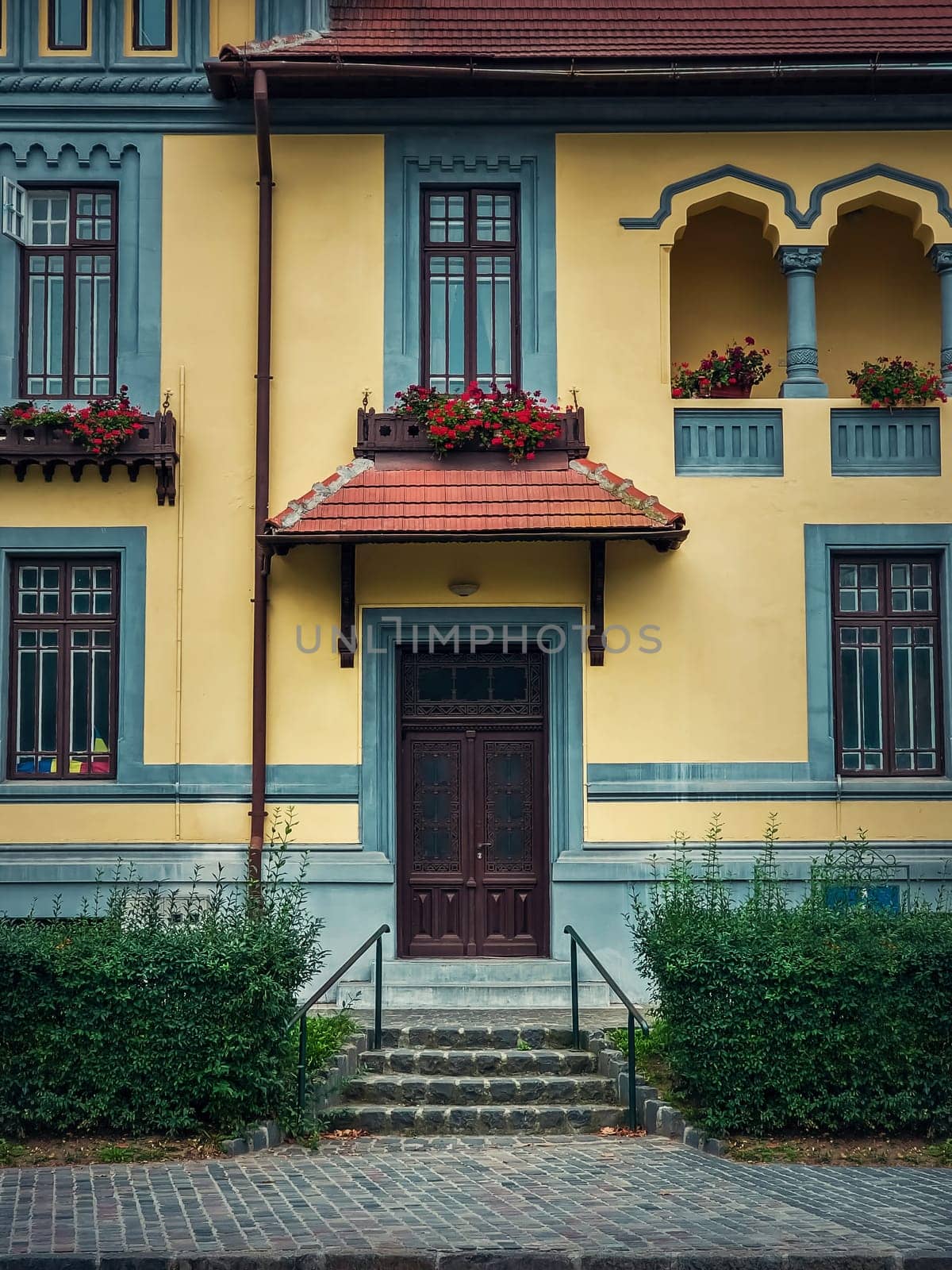 Colorful house facade, vintage style with retro porch and awning. Traditional european building exterior, front view at entrance door