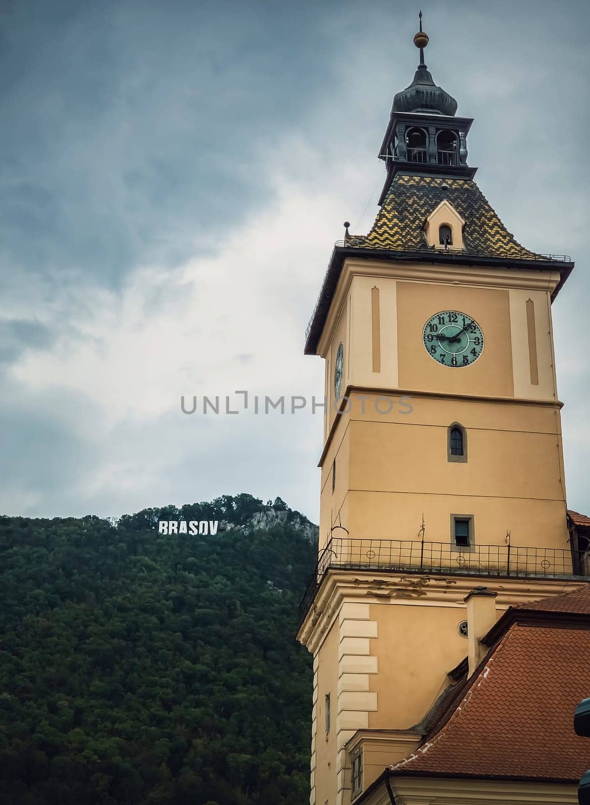 The council house clock tower with a beautiful view to the Brasov sign on top of the hill. Popular tourist location in Romania