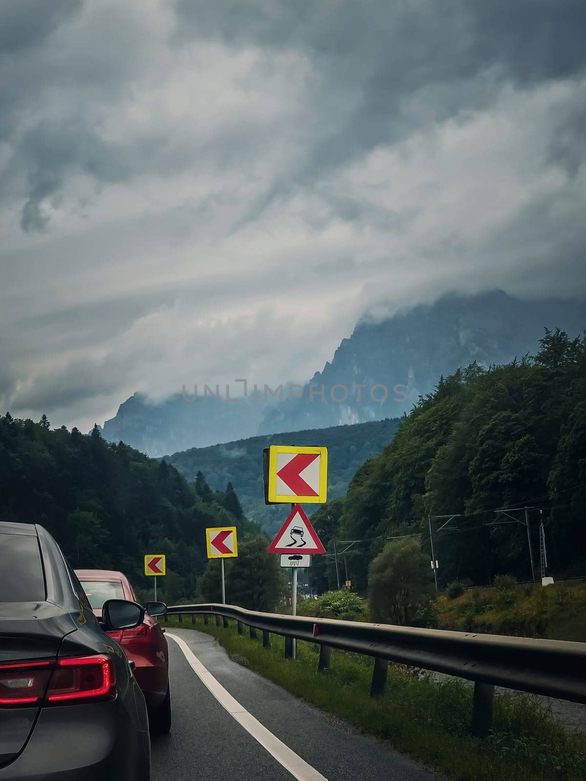 Car moving on a serpentine roadway between the mountains by psychoshadow