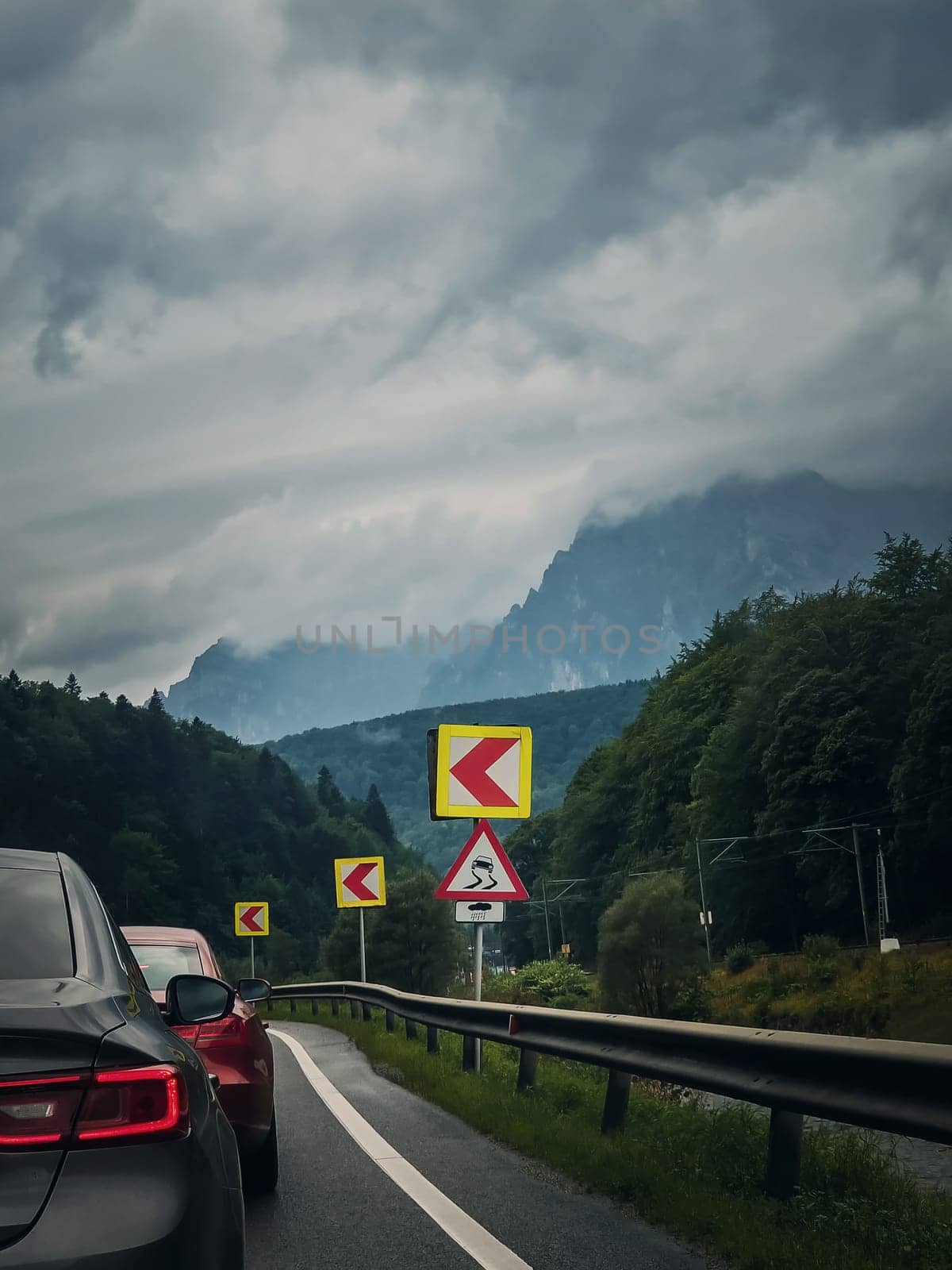 Car moving on a serpentine roadway between the mountains