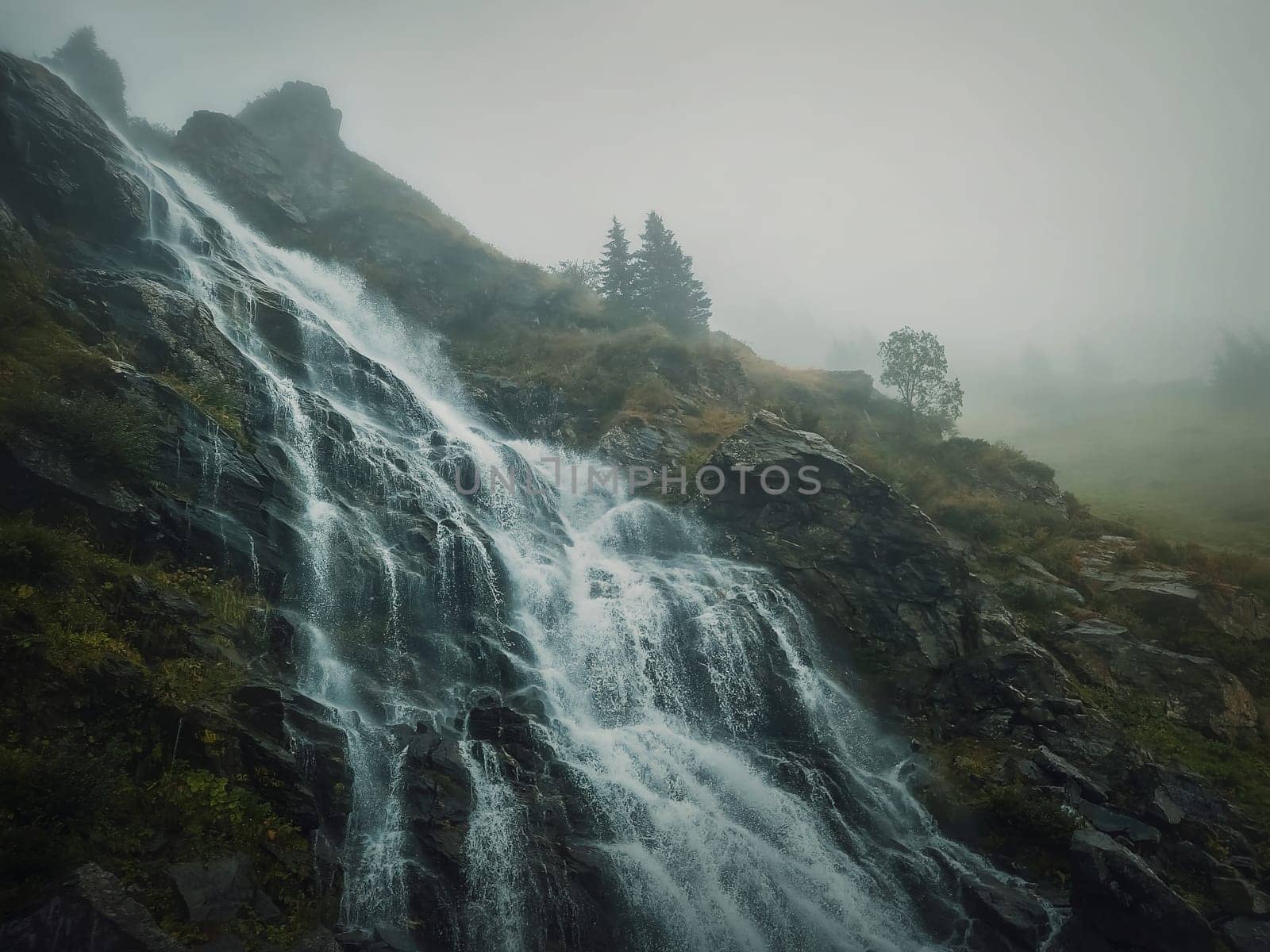 Capra waterfall on the Transfagarasan route in romanian Carpathians. Idyllic scene with a big river flowing down through the rocks in a misty autumn morning by psychoshadow