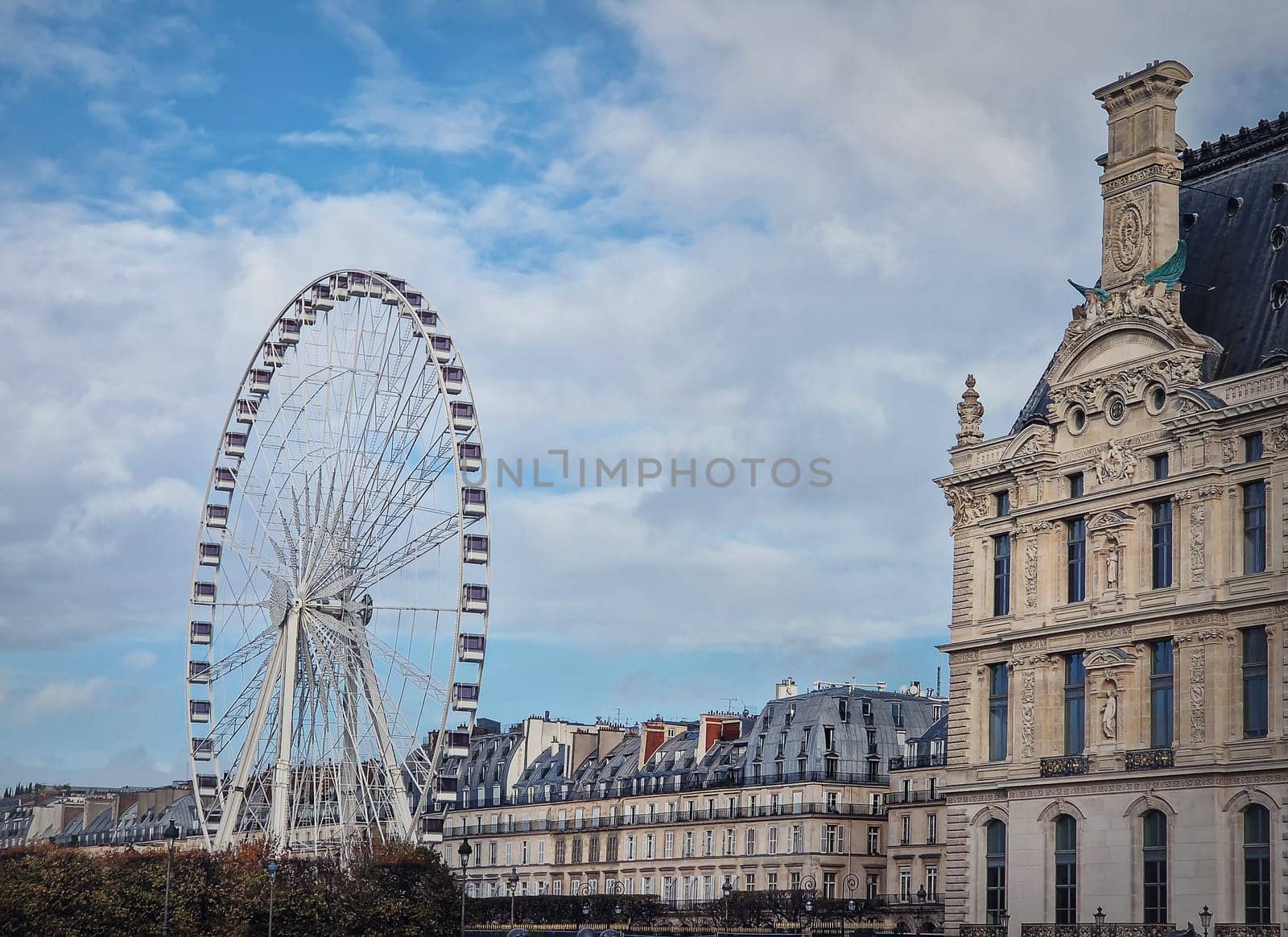 Grande Roue de Paris ferris wheel next to Louvre museum building and parisian houses, France by psychoshadow